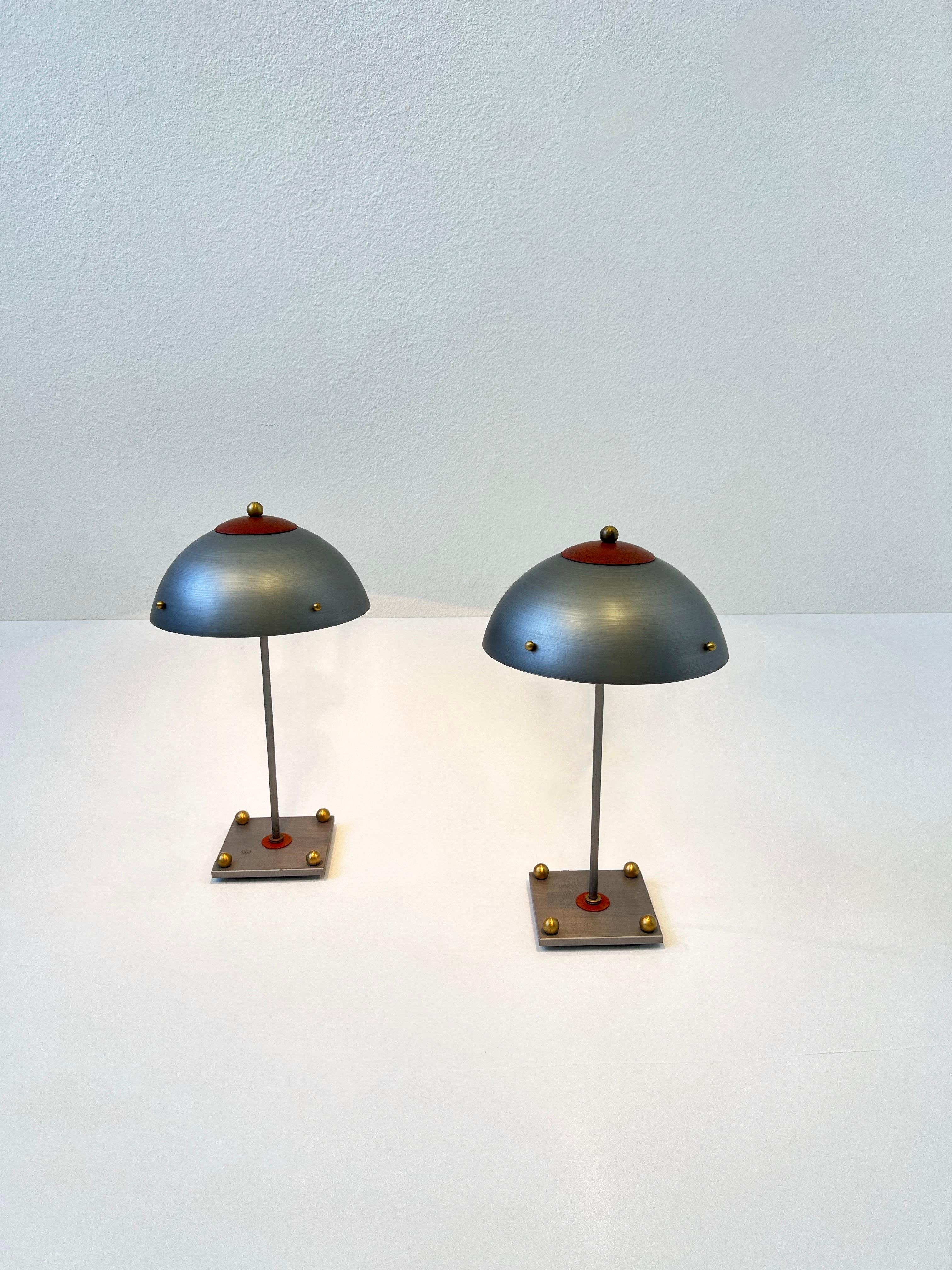 Pair of 1980’s Studio Post Modern steel and brass table Lamps by Cantor Wheat Design. 
In beautiful original vintage condition, some age spots on one. 

They have a High/Low in line dimmer and take two small 40w Max lightbulbs. 

Measurements: