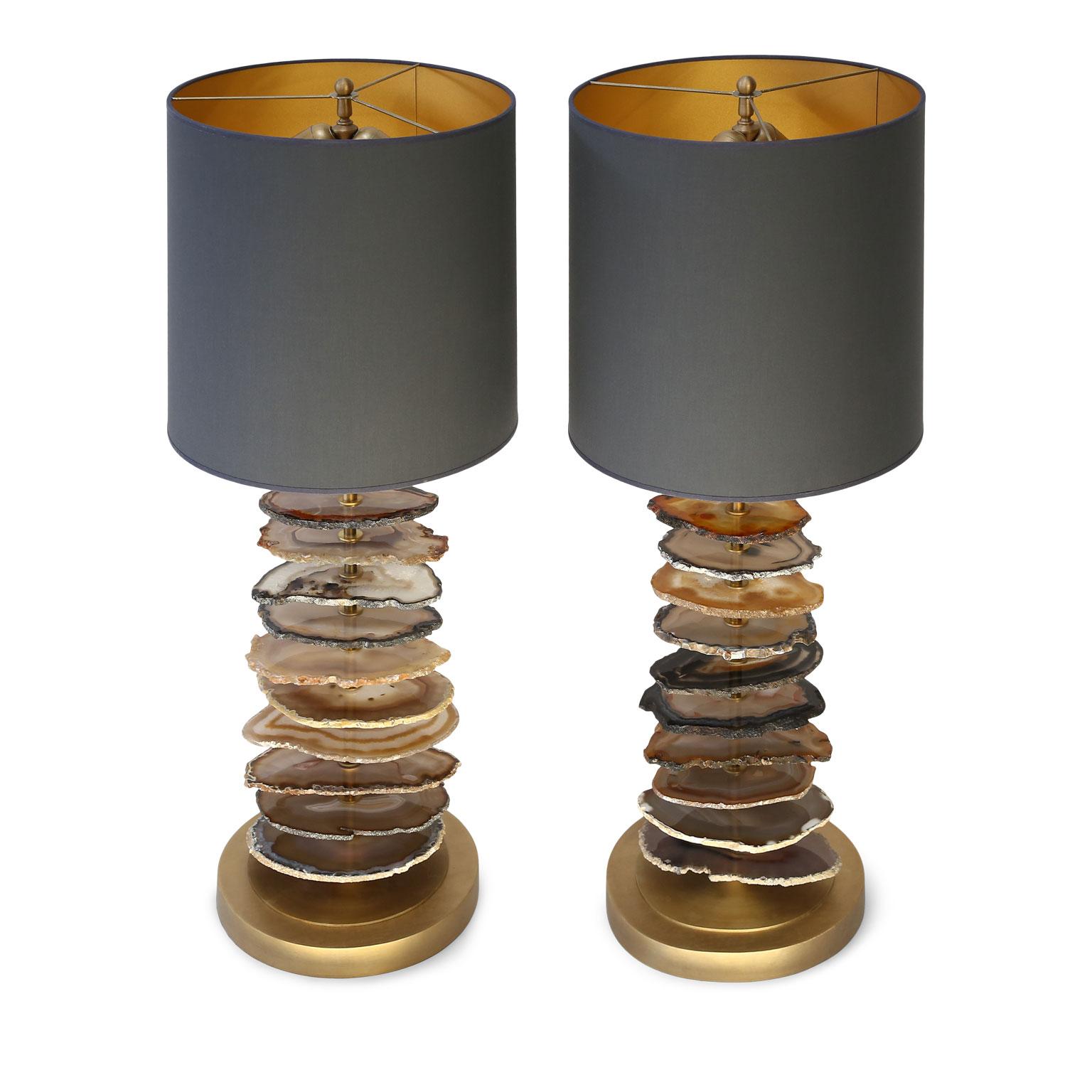 Pair of stunning custom agate lamps by Francine Villier-levy. Cross sections of agate stacked in a graduated fashion upon a gilt steel base. Newly wired for use within the USA. Includes charcoal gray linen drum shades, lined in gold paper. Listed