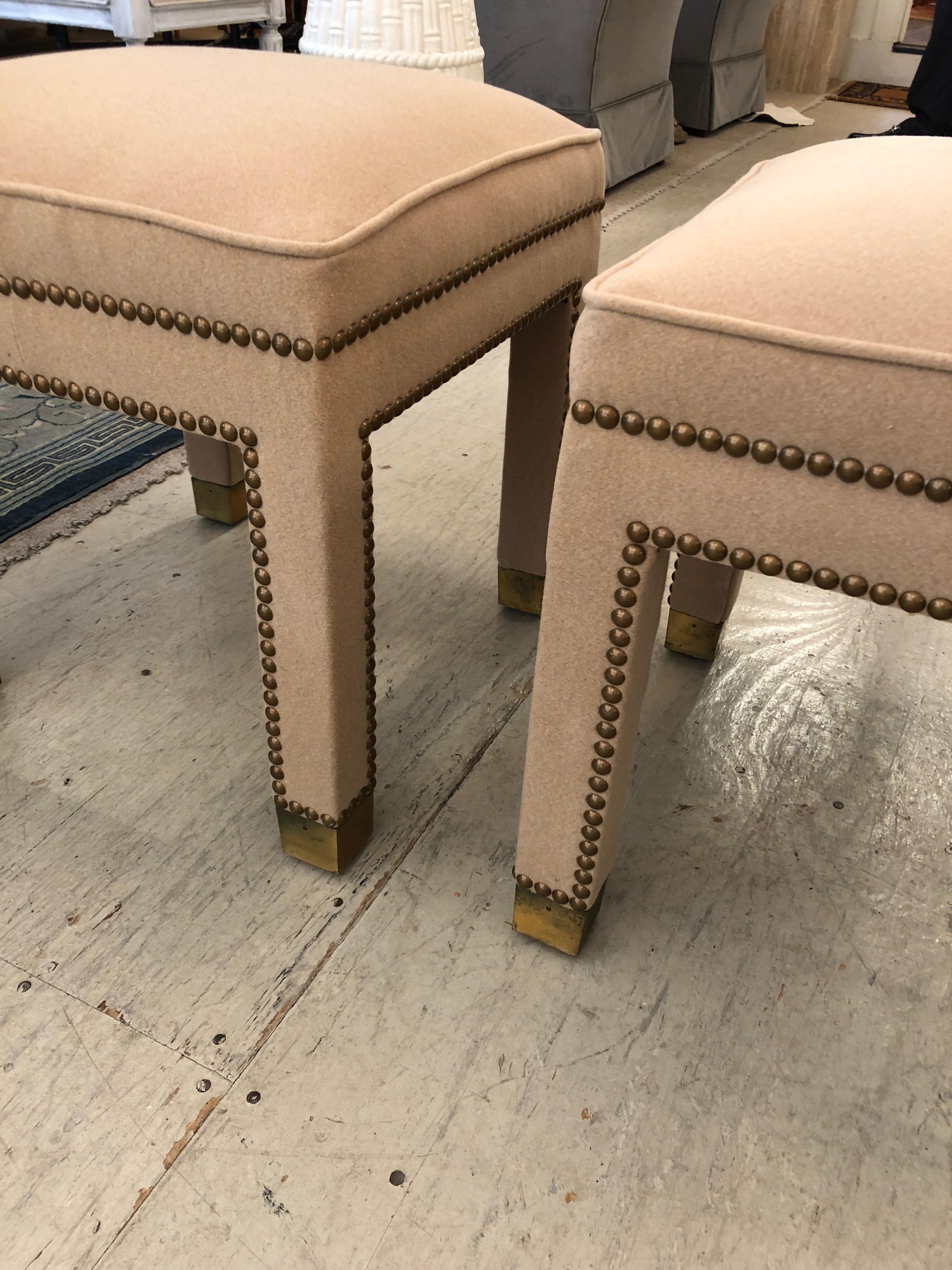 Two vintage Mid-Century Modern ottomans completely redone in sumptuous camelhair with brass nailheads and stunning original brass caps on the feet. Could be used as a coffee table in front of a sofa.