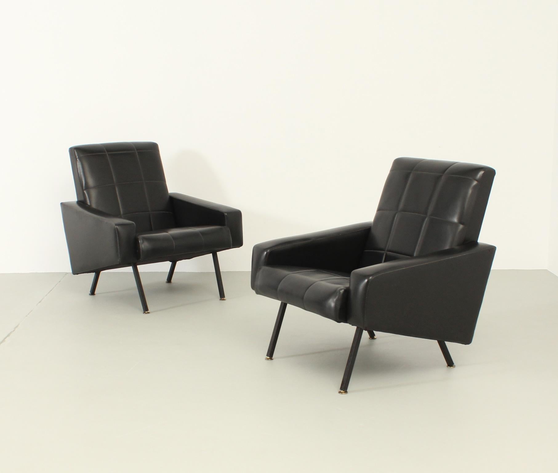 Pair of stylish armchairs produced by Meurop, Belgium in 1950's. Black lacquered metal bases with brass fittings and original black vinyl upholstery.