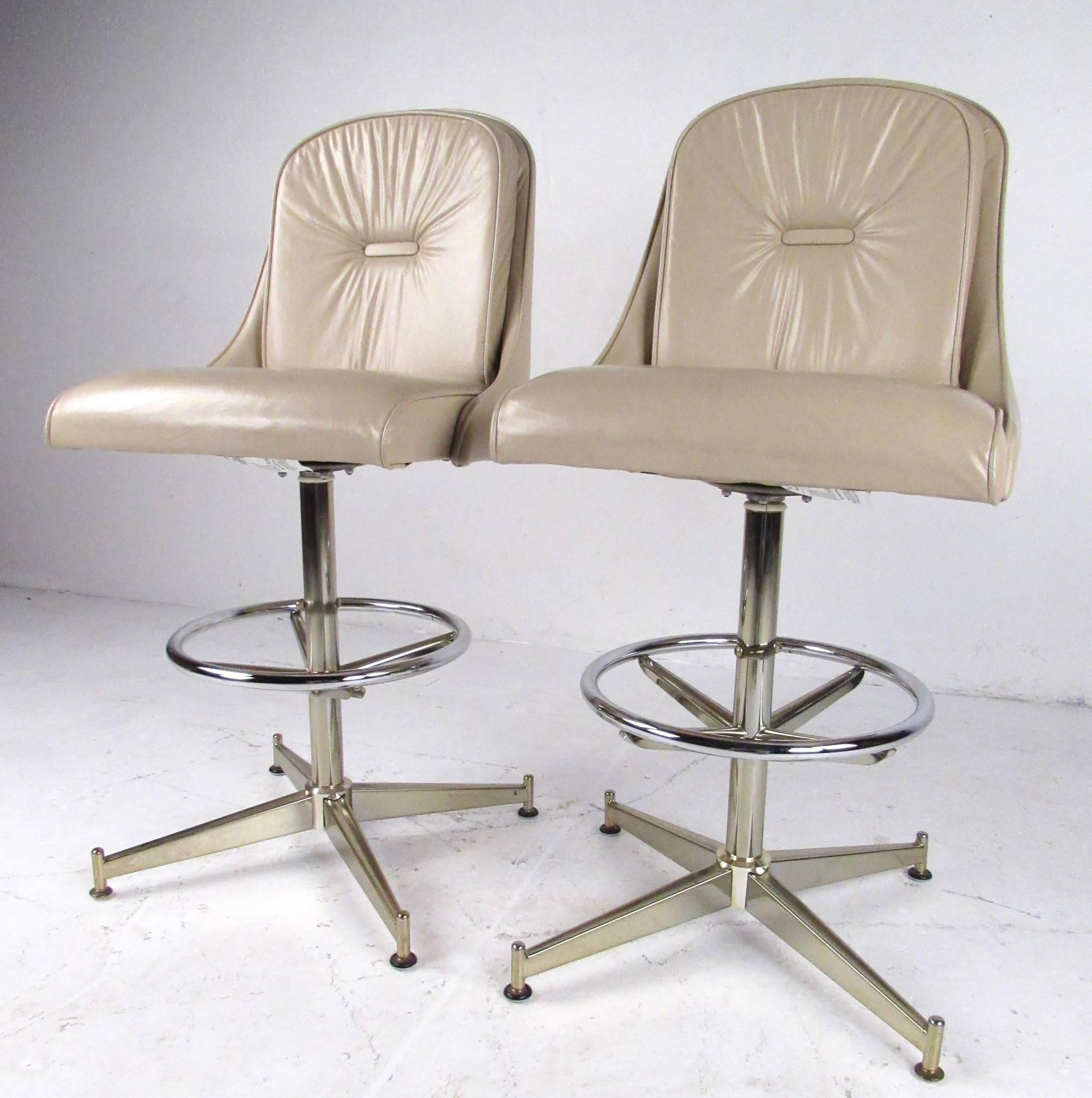 This vintage modern pair of barstools by Daystrom feature swivel seats, sturdy metal frames, and fixed twenty seven inch seat height. Striking pair of vinyl barstools for home or restaurant bar seating, please confirm item location, (NY or NJ).