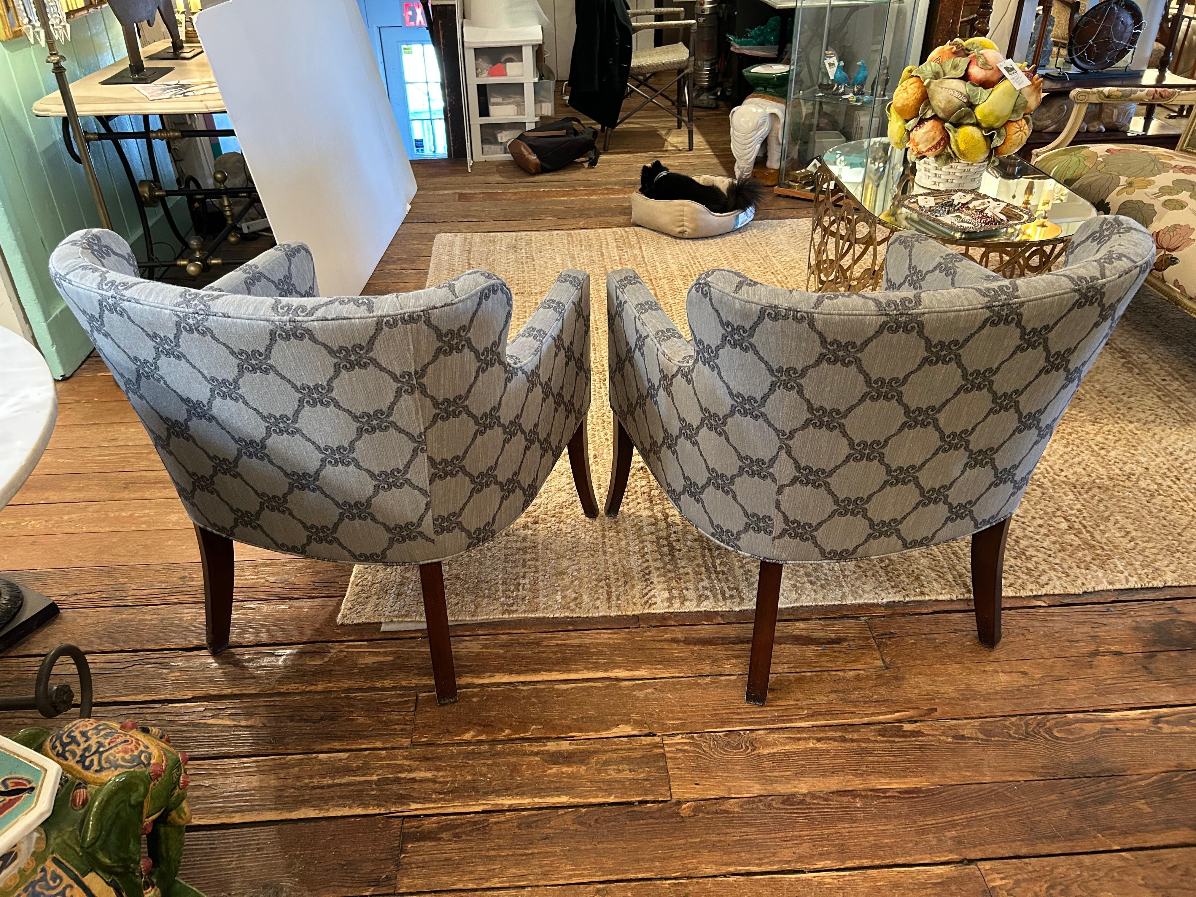 Stylish comfortable pair of upholstered club chairs having curved backs, greyish blue patterned fabric and dark wood tapered legs.
Arm height 24.5