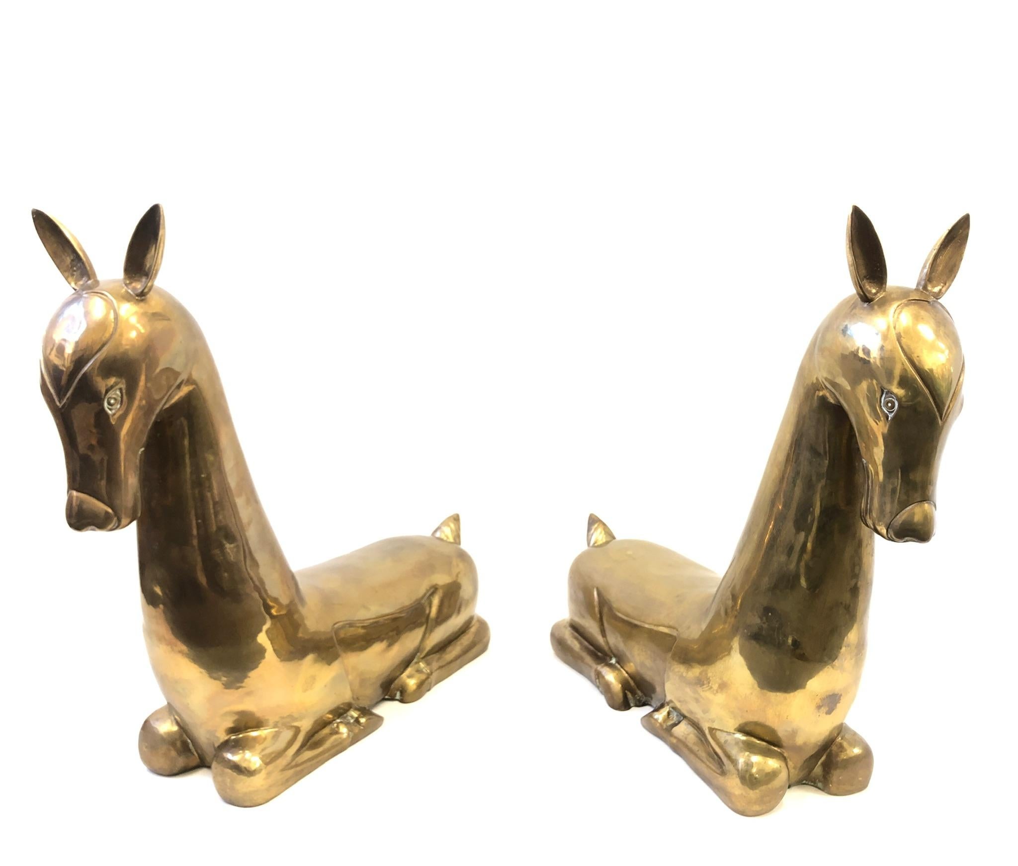 Pair of large stylized brass deer sculptures from the 1970s. The sculpture have an aged brass finish, they can be polished if desired. Each sculpture is 34.75” high 37” wide 12” deep.