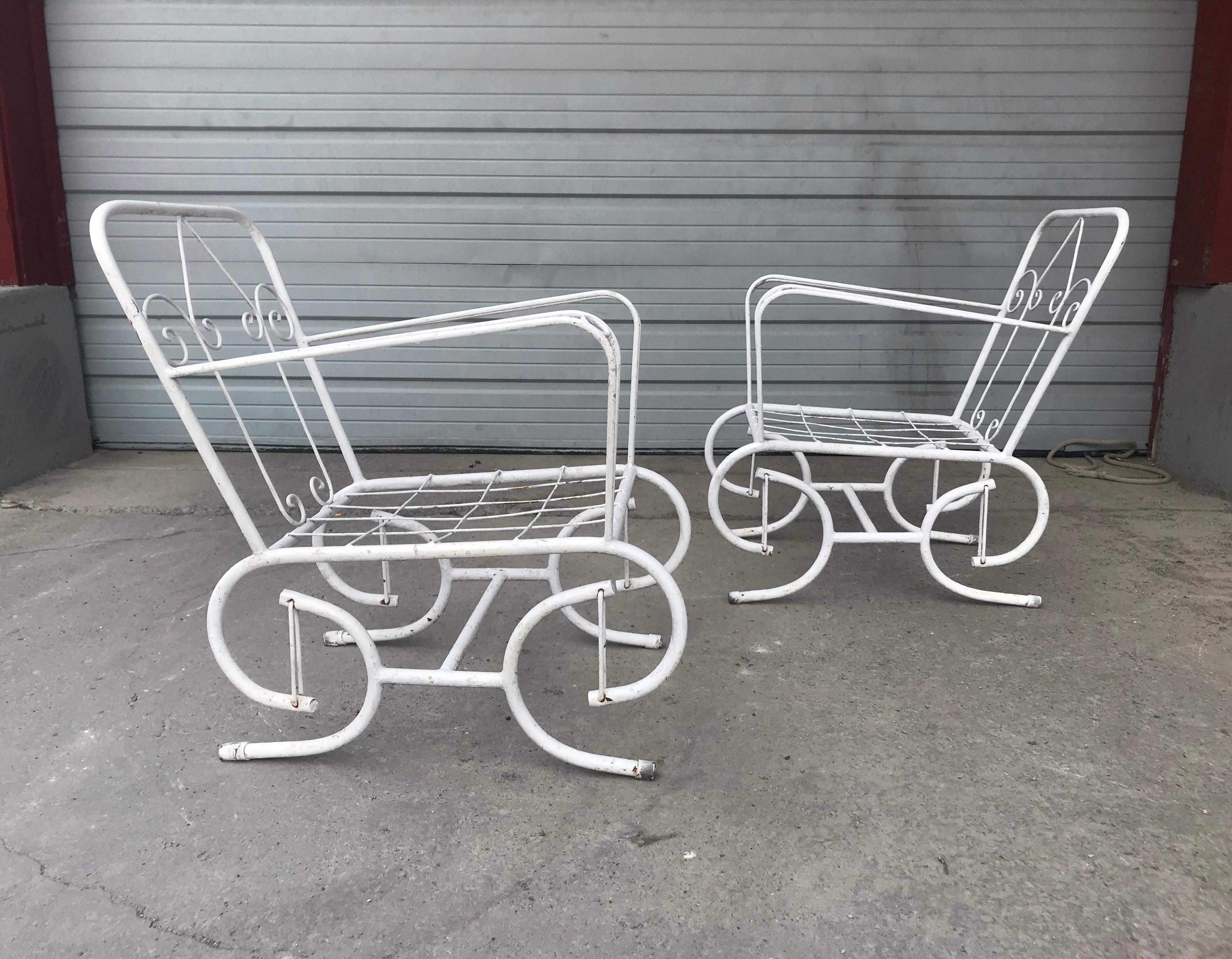 Pair of stylized outdoor metal glider chairs. Nice quality and construction. Unusual modernist design. Hand delivery avail to New York City or anywhere en route from Buffalo NY.