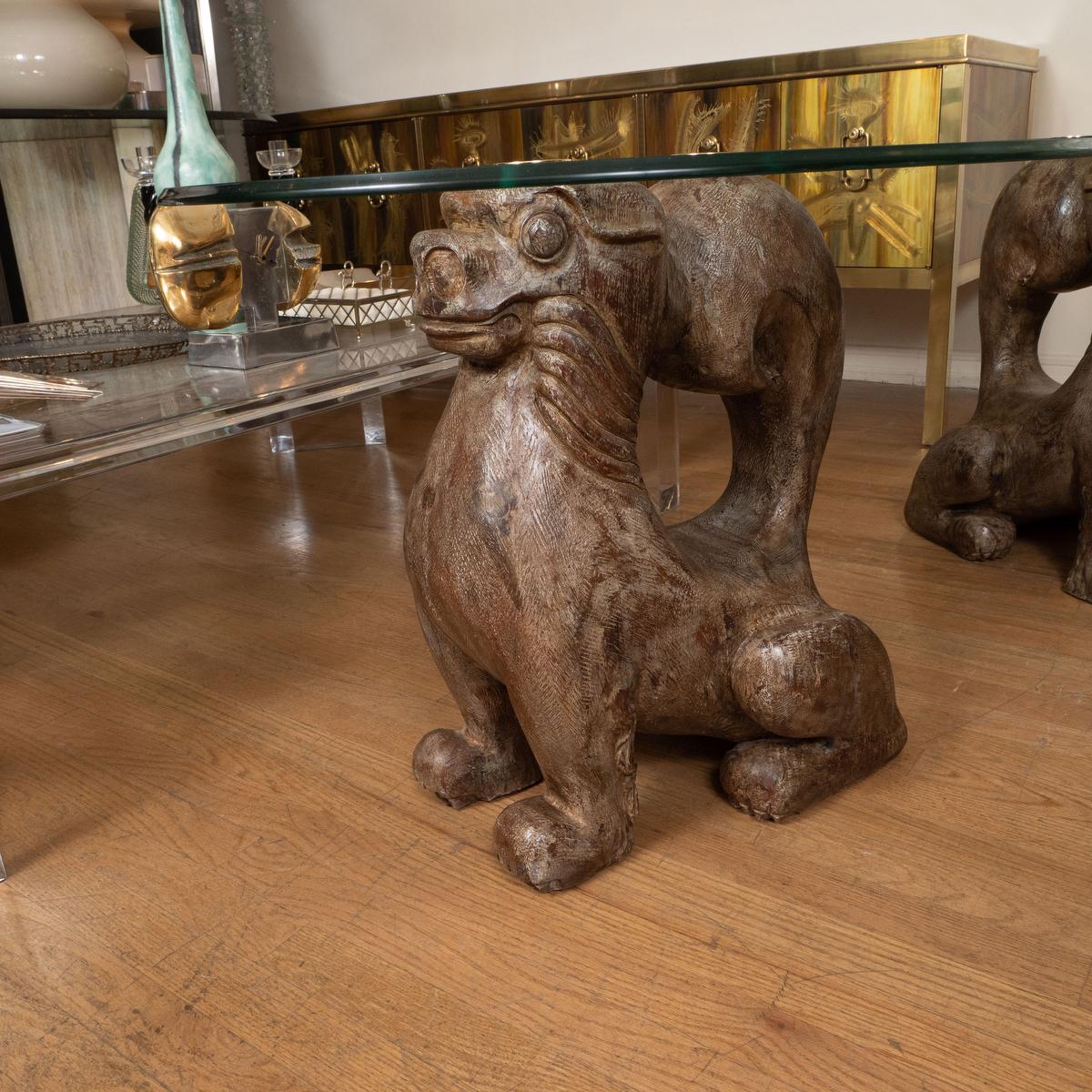 Pair of stylized wood carved dog side tables with brass and glass tops by Sarreid.