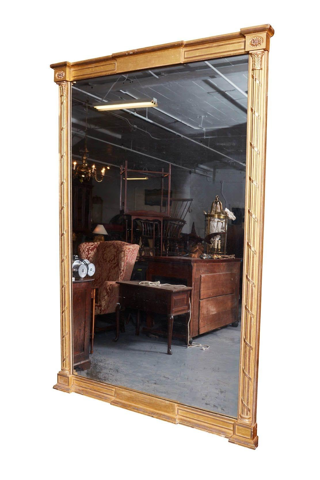 Importante paire de miroirs en bois doré de George III, d'une taille substantielle. Le fronton est orné de paterae ovales insérées sur des colonnes corinthiennes nervurées avec des bandes de ruban, la base est conçue de la même manière, le tout en