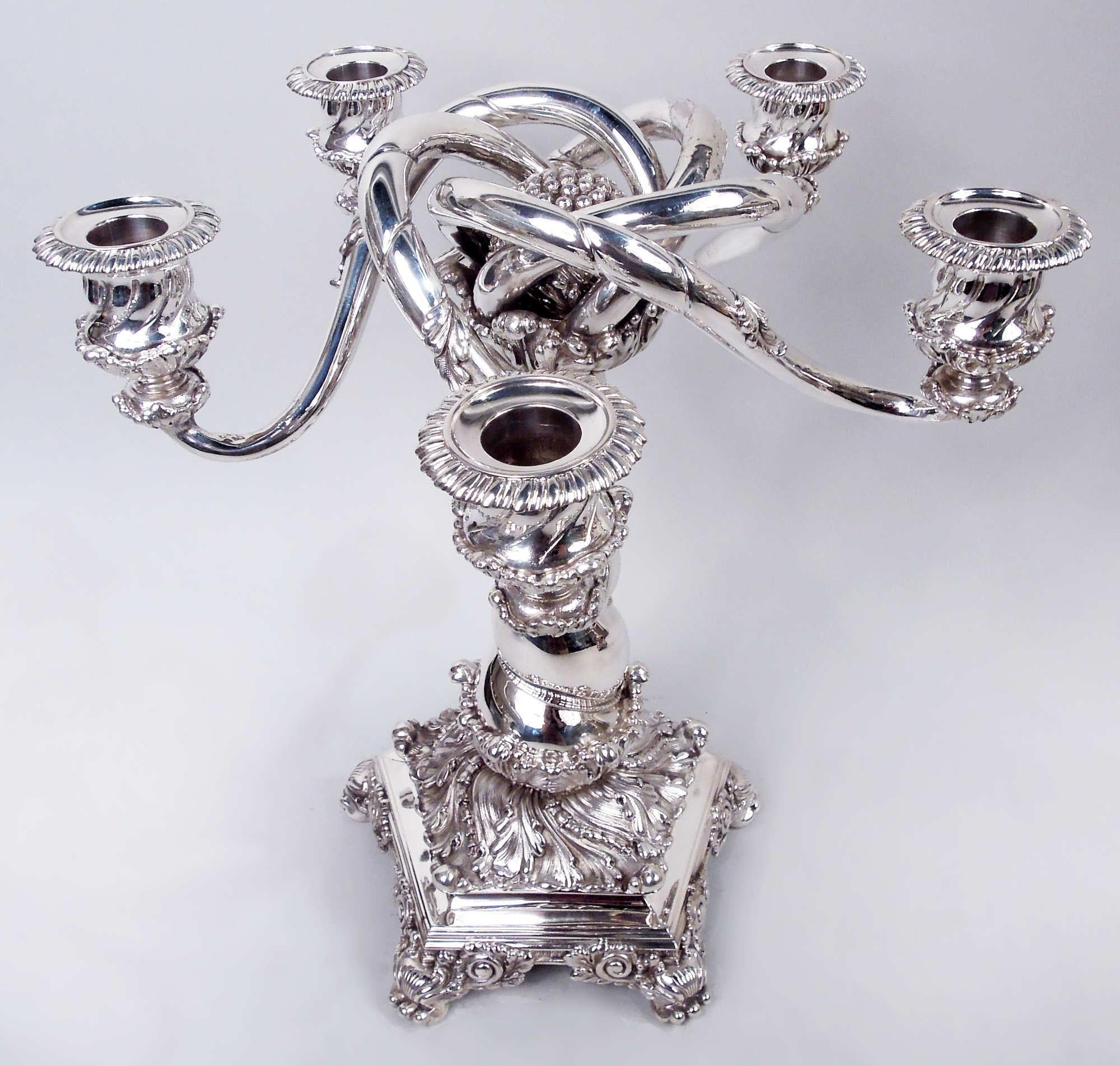 Pair of Victorian Classical sterling silver 5-light candelabra. Made by Tiffany & Co. in New York, ca 1883. Each: Central flower bud surrounded by five wraparound s-scroll arms rooted in leaf surround; each arm leaf-wrapped with twisted lobing
