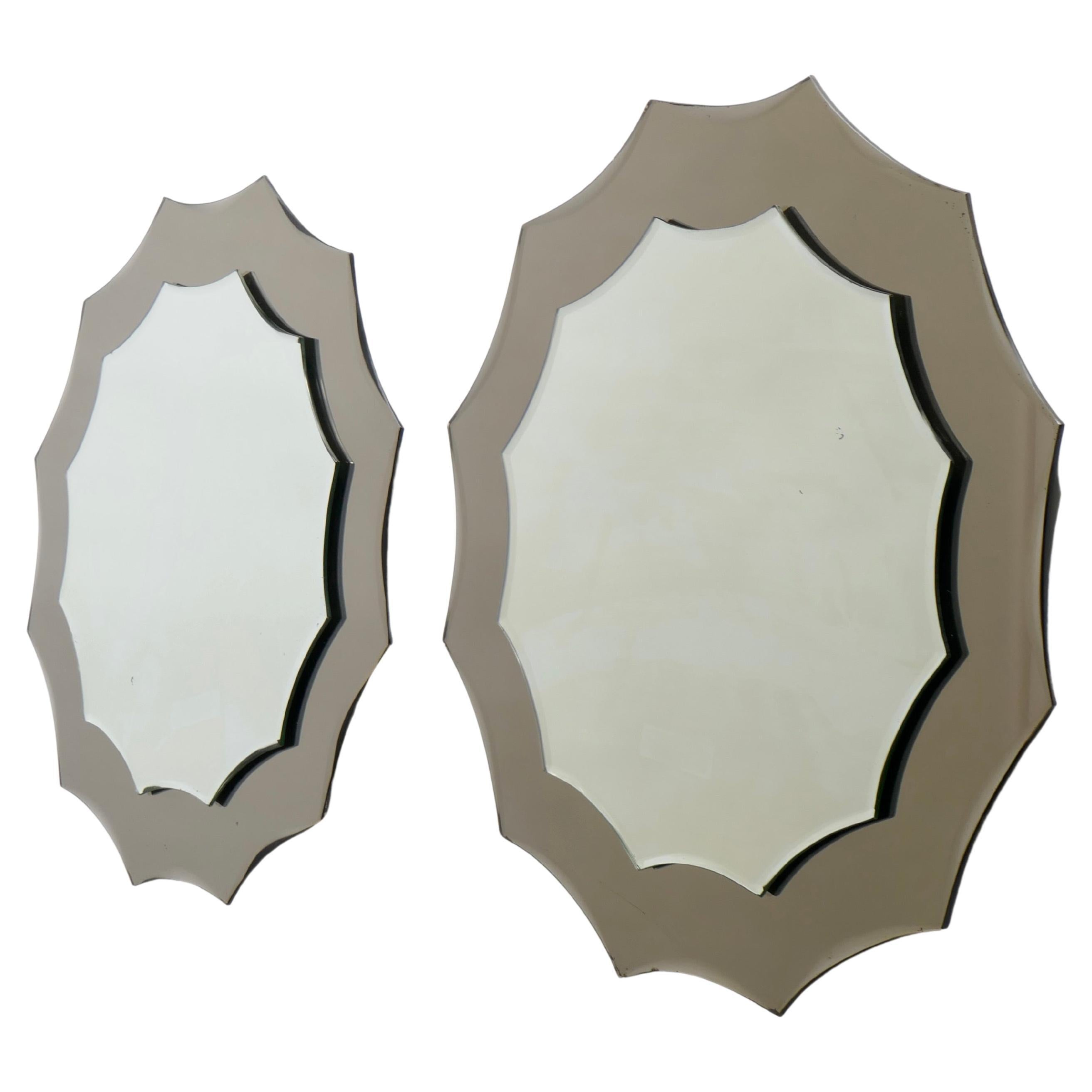 A pair of sun-shaped mirrors, each designed as a central scalloped glass set upon a larger bronze-tinted glass of identical design, produced in Italy in 1970s in the style of Fontana Arte. The mirrors are in excellent condition and add a playful