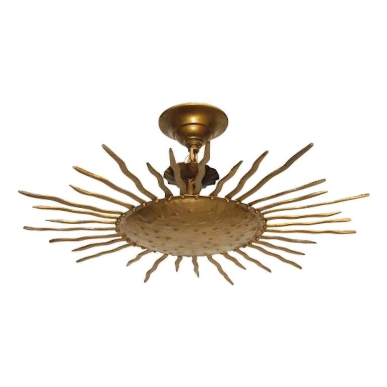 Pair of circa 1940's French gilt metal sunburst shaped light fixtures with interior lights and original patina. Sold individually.

Measurements:
Diameter: 24