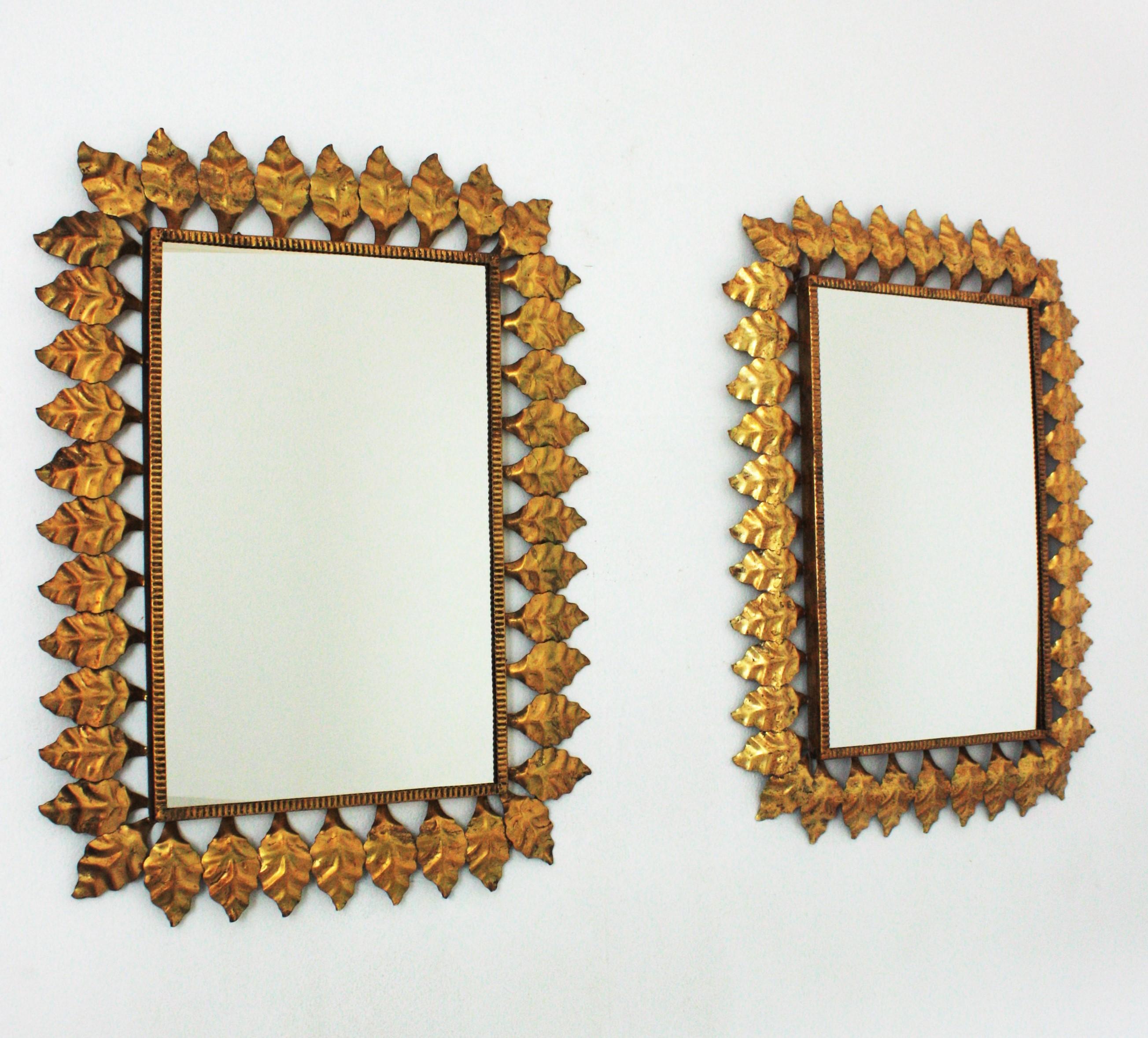 Pair of hand-hammered iron sunburst rectangular wall mirrors with gold leaf finish, Spain, 1950s.
Highly decorative rectangular leaf framed sunburst mirrors with gold leaf gilding and large glass surfaces.
They have a nice aged patina showing