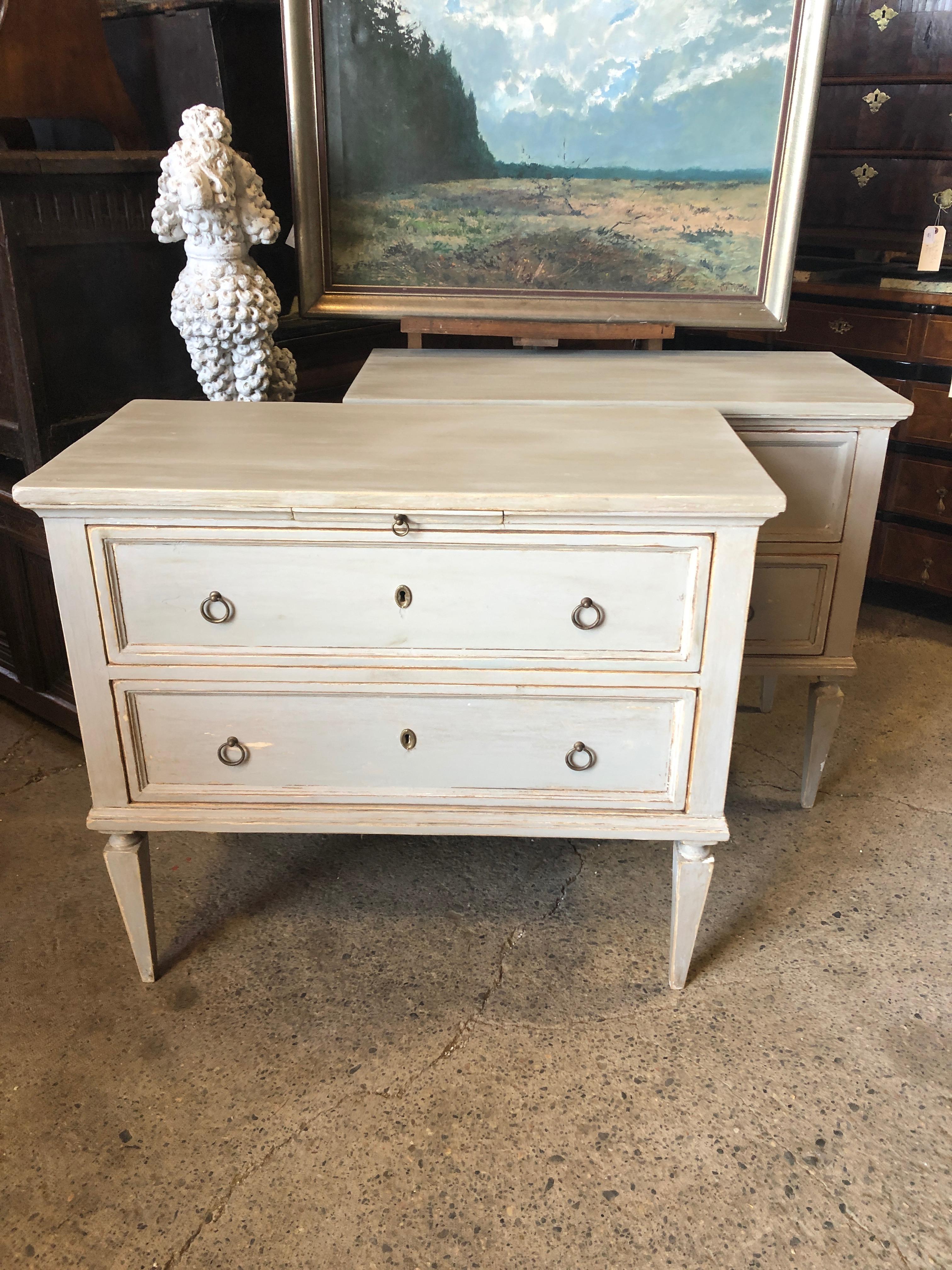 A pair of antique Swedish Gustavian painted wood chests from the early 19th century, with beautiful classic long tapered fluted legs, original hardware and original pull-out writing shelves. Lovely Swedish Blue Gray distressed paint finish. Born in