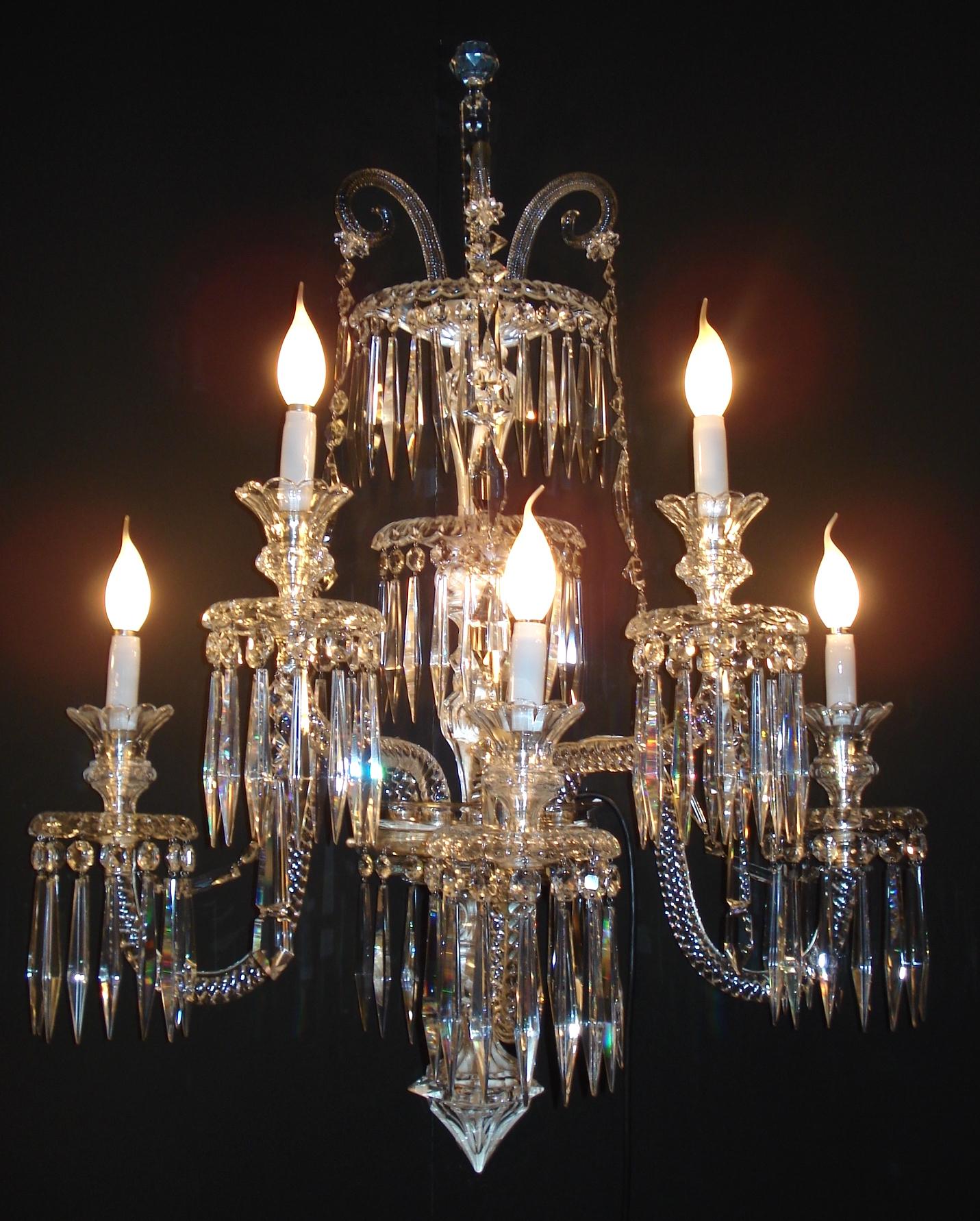 A magnificent pair of large early 20th century Baccarat crystal five-light sconces. Gorgeous cut crystal column, gracefully curved arms, beautifully adorned crown and elegant draped beaded crystal strands.
 Rewired and perfectly restored. The