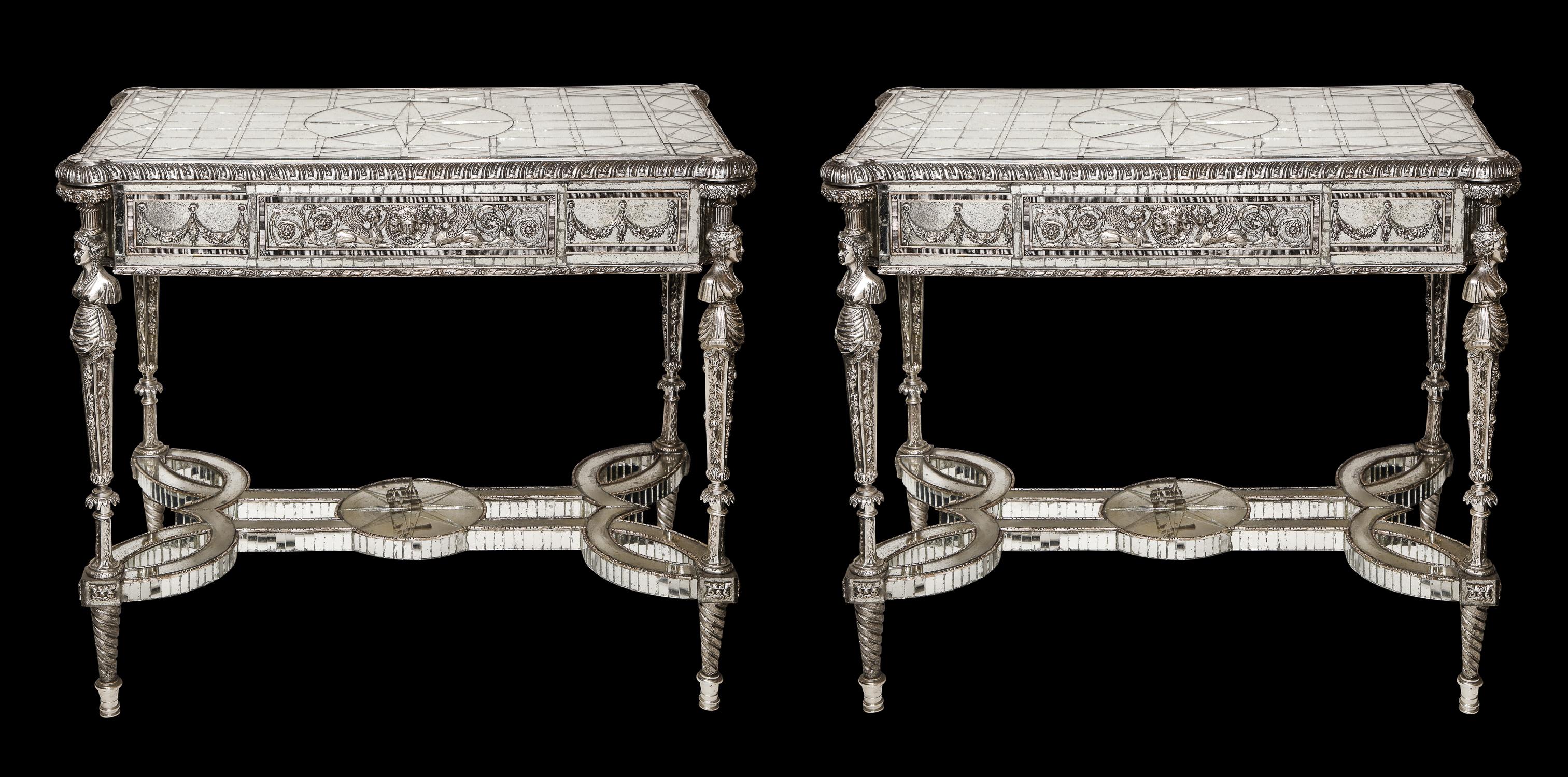 A pair of magnificent and rare French Louis XVI Style silvered bronze and antiqued mirrored rectangular form figural center/ side/console tables of exquisite craftsmanship. Each table is embellished with 100's of antiqued mirror mosaic pieces