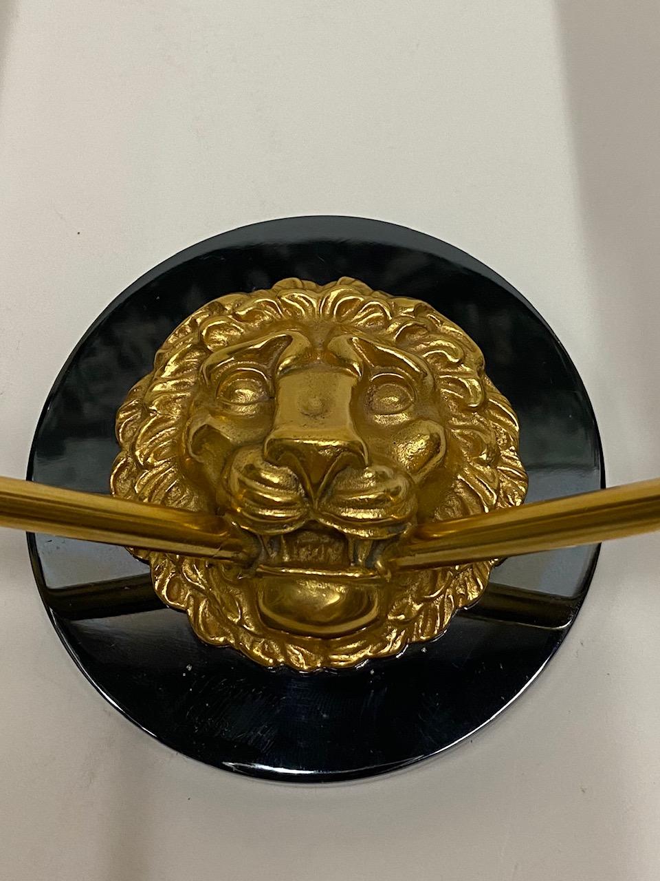 Pair of supremely elegant French neoclassical style wall sconces having central gilt bronze lion medallion set against nickel plated discs, with arrow decoration and two arms in each. Gorgeous casting and newly rewired.