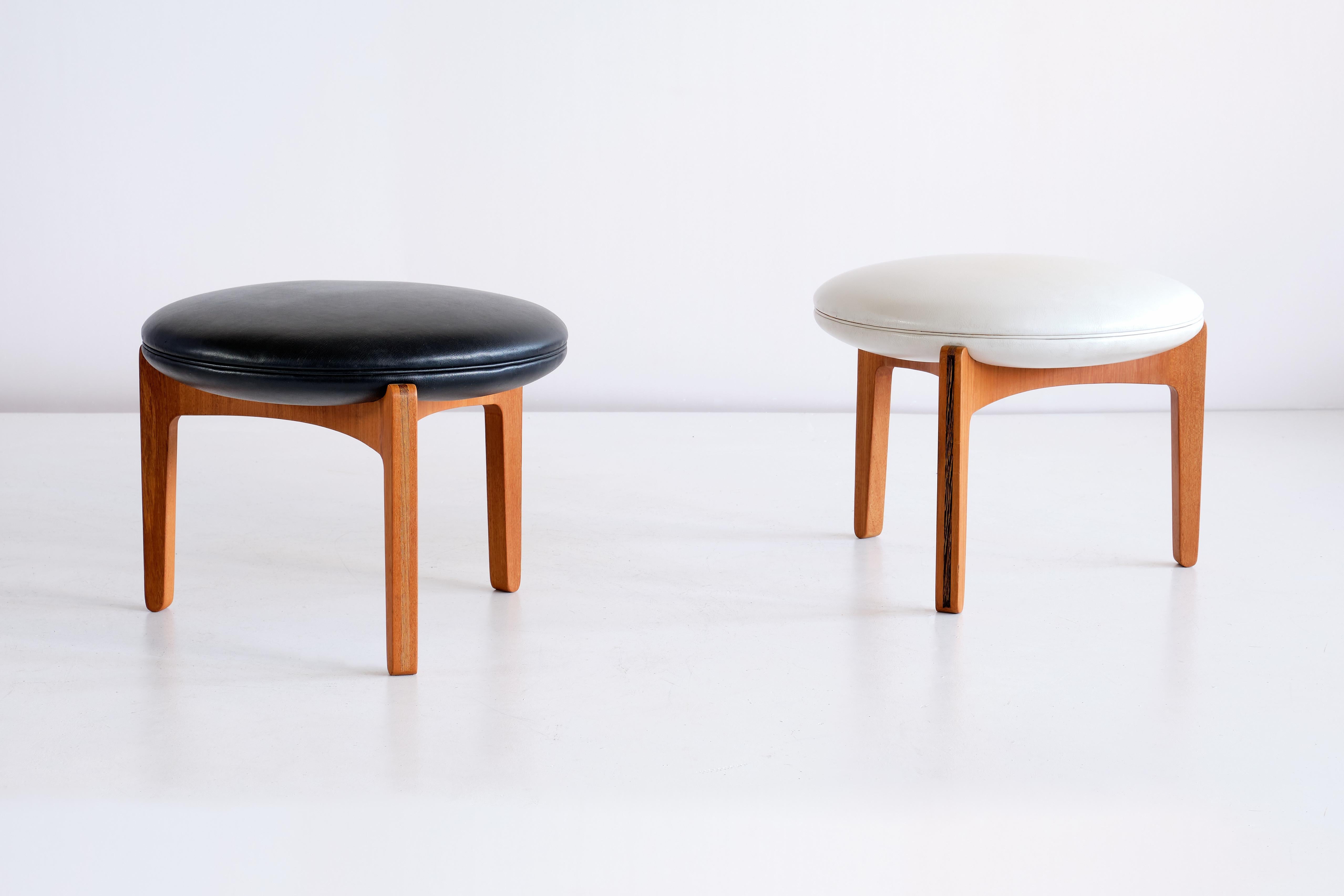 This striking pair of stools was designed by Sven Ellekaer and produced by Christian Linneberg Møbelfabrik in Denmark, 1962. The round seat pads are upholstered in a black and white vinyl leather, resting on a three-legged frame in teak wood. The
