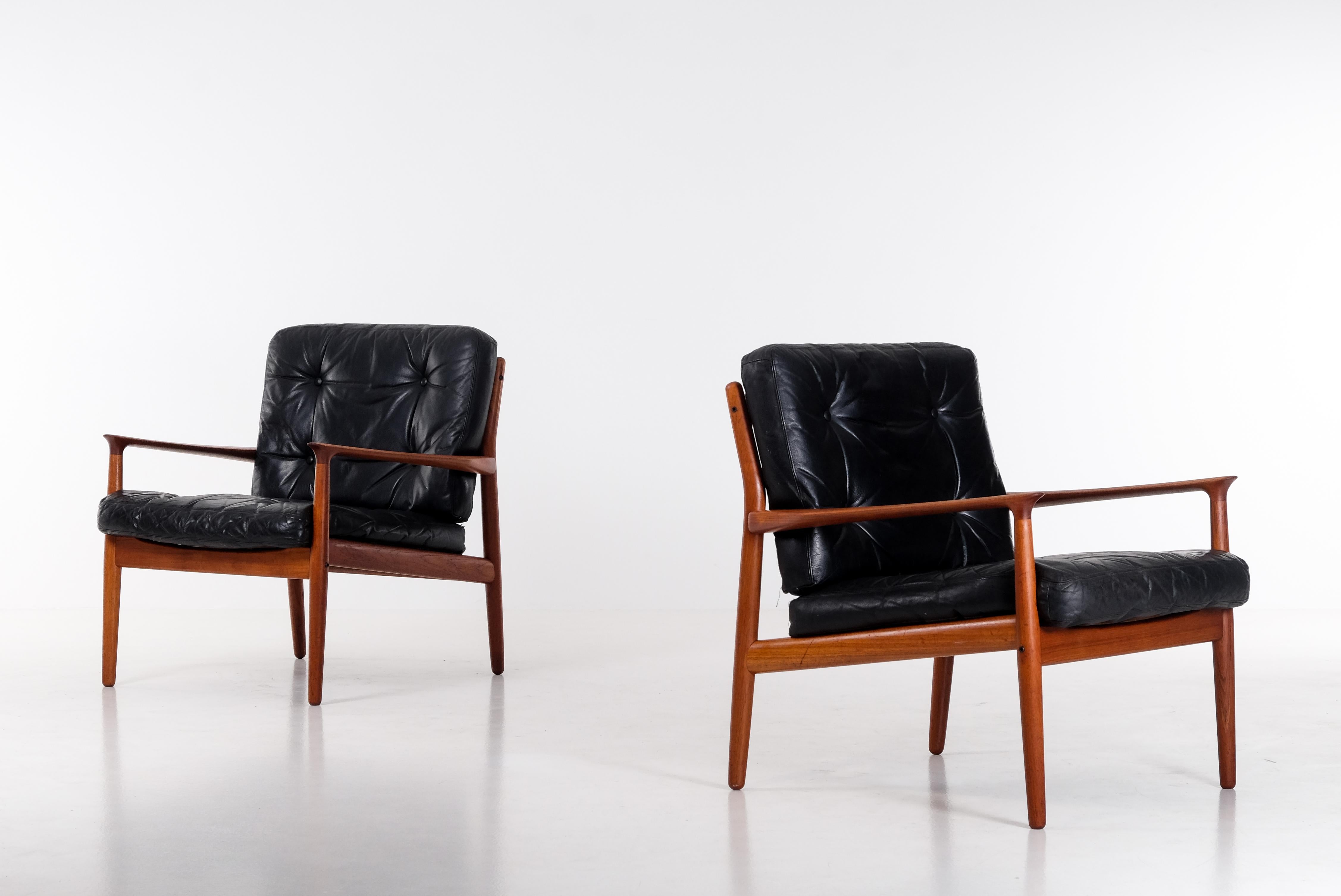 Coppia di poltrone Svend Aage Eriksen, prodotte in Danimarca negli anni '60. 
Struttura in teak e cuscini in pelle nera. 