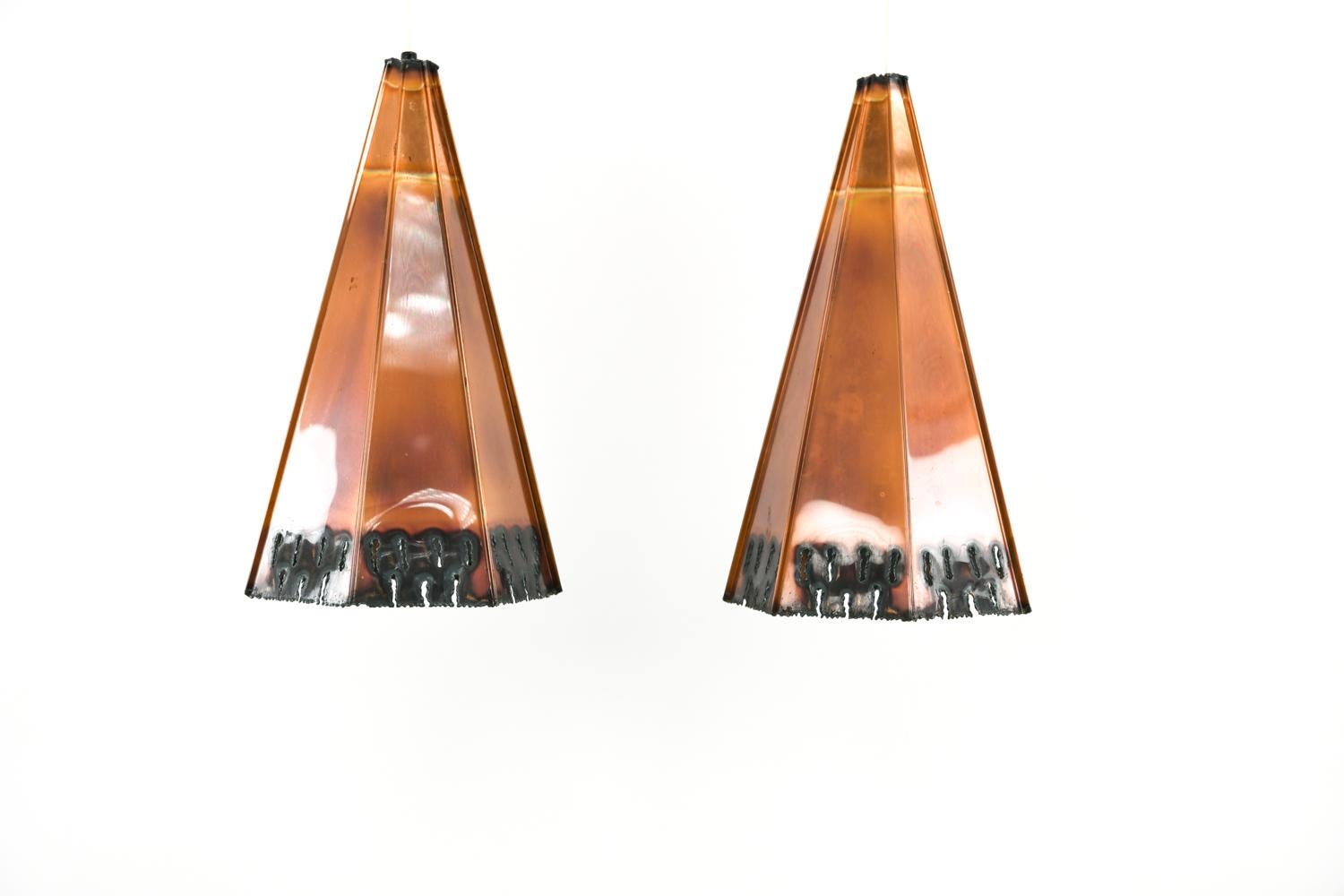 A pair of Danish midcentury Brutalist pendant lights designed by Svend Age Holm Sorensen, circa 1960s. These pendant lights feature patinated, burnt copper in a rare faceted cone design.