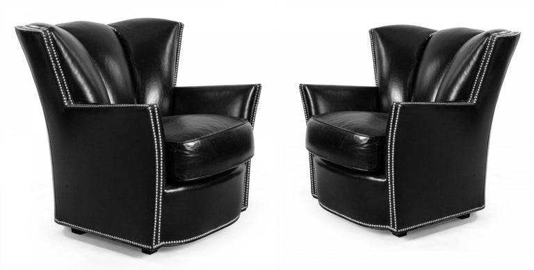 Pair of contemporary black leather club chairs with thick seat cushions, tufted backs and studded detail along frame and armrests by Swaim.
