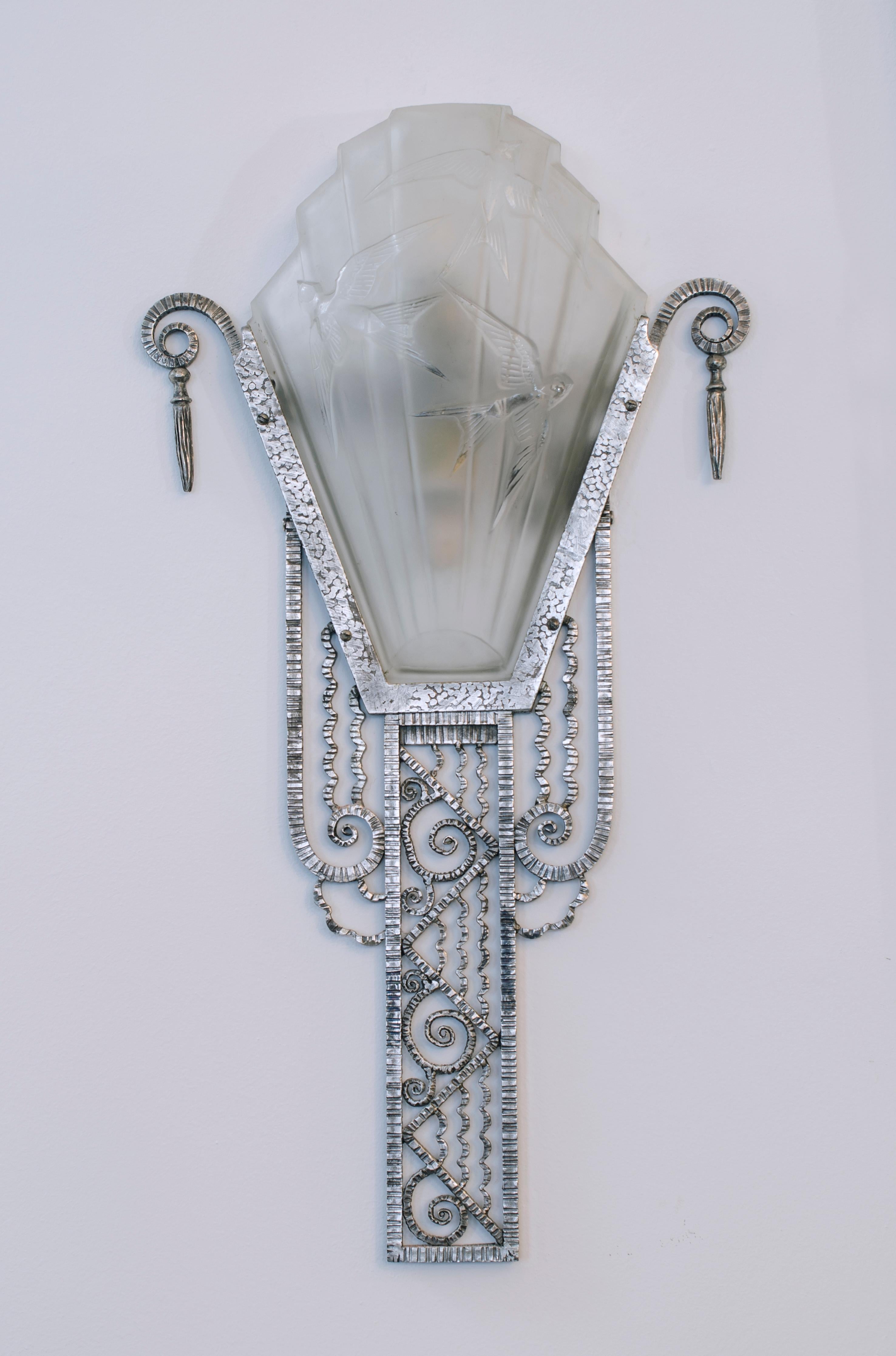 Pair of silver-plated iron frame wall lights with satin glass plate, swallow model. By Marius Ernest SABINO