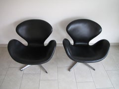 Pair of Swan chairs in black leather by Arne Jacobsen for Fritz Hansen