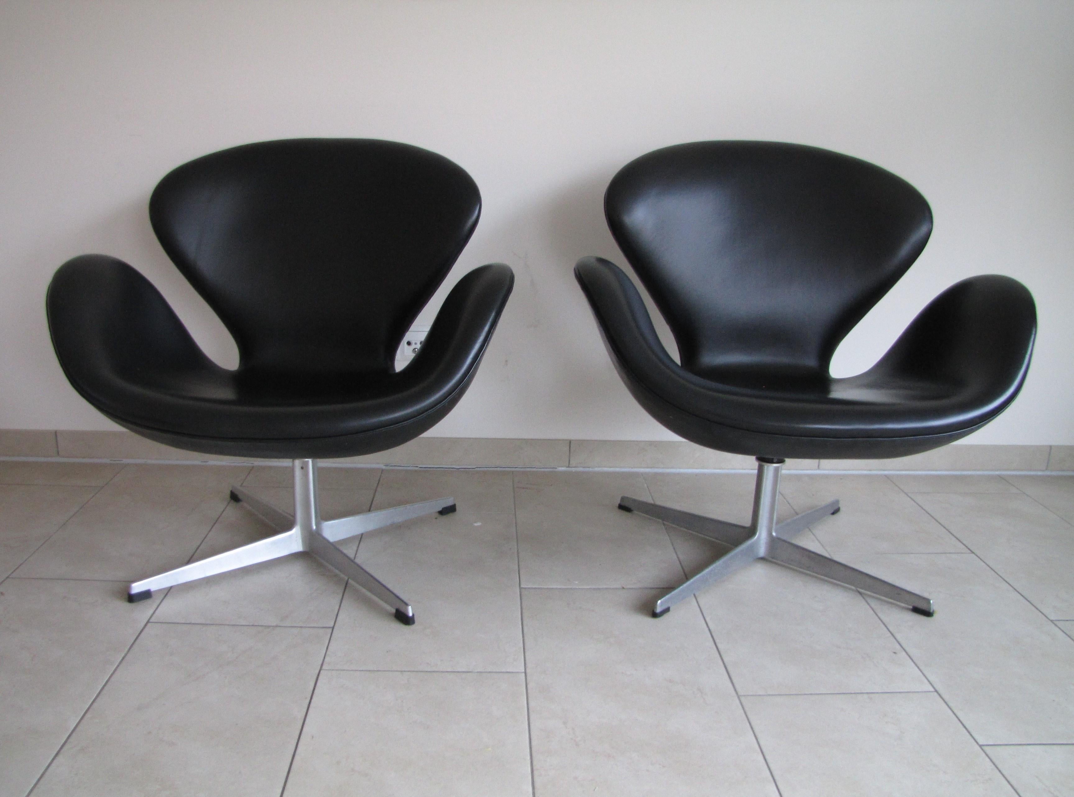 Aluminum Pair of Swan chairs in black leather by Arne Jacobsen for Fritz Hansen For Sale