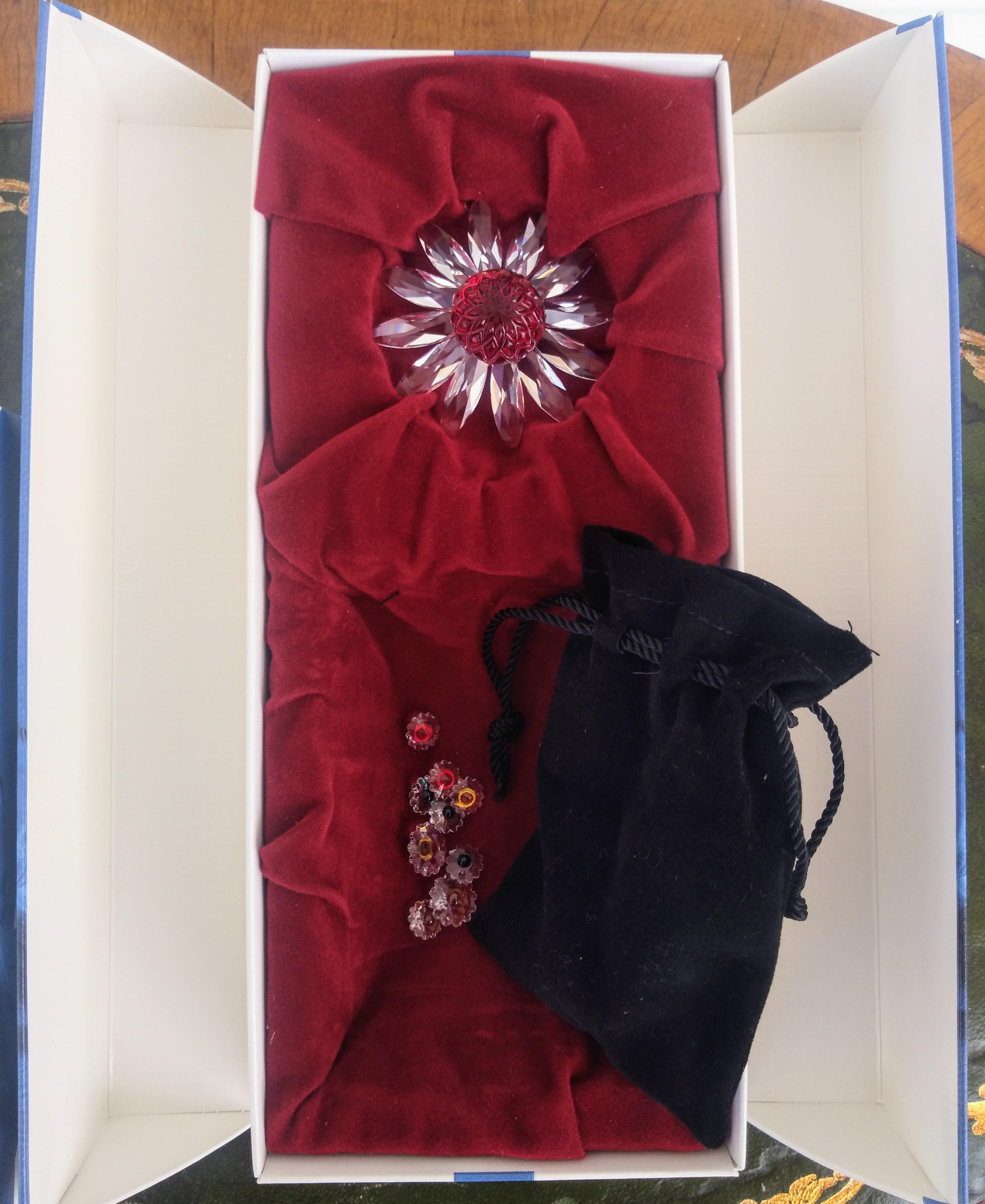 Questi pezzi di cristallo Swarovski provengono dal kit per i soci. Un fiore è rosso e l'altro verde. All'interno della borsa nera si trovano 43 fiori di cristallo di dimensioni diverse.
Sono tutti nella scatola originale.