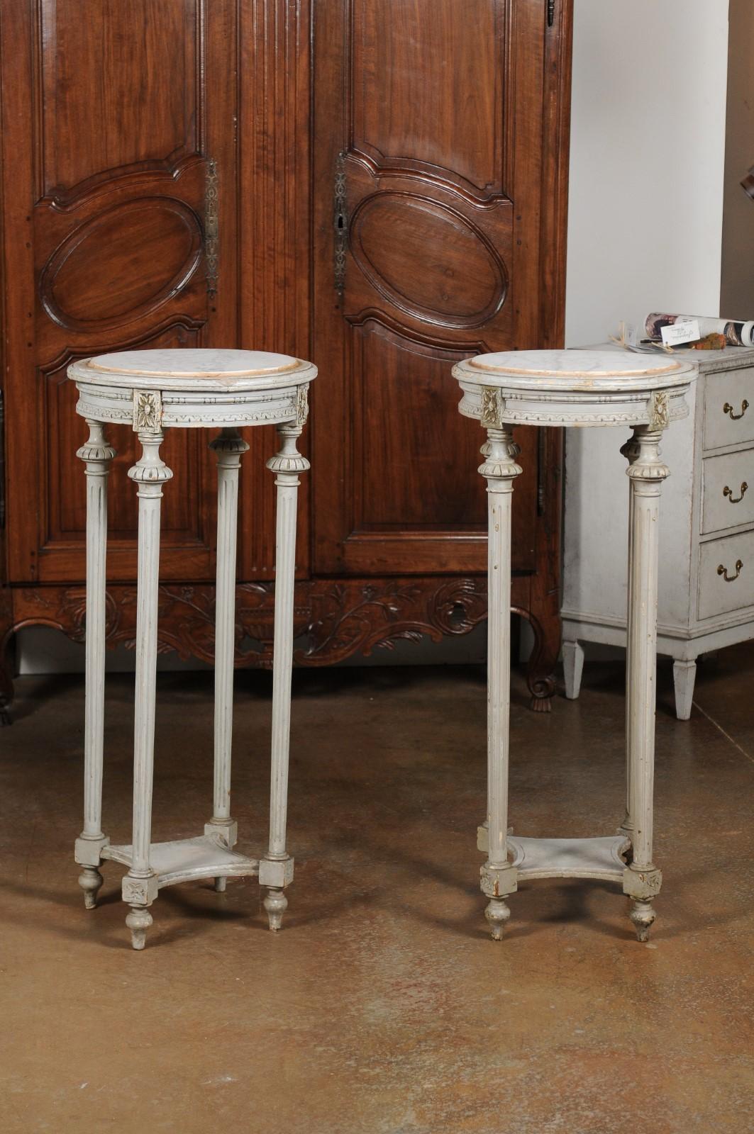 A pair of Swedish neoclassical painted wood pedestal stands from the early 19th century, with Carrara marble tops. Born in Sweden during the second quarter of the 19th century, each of this pair of neoclassical stands features a circular top made of