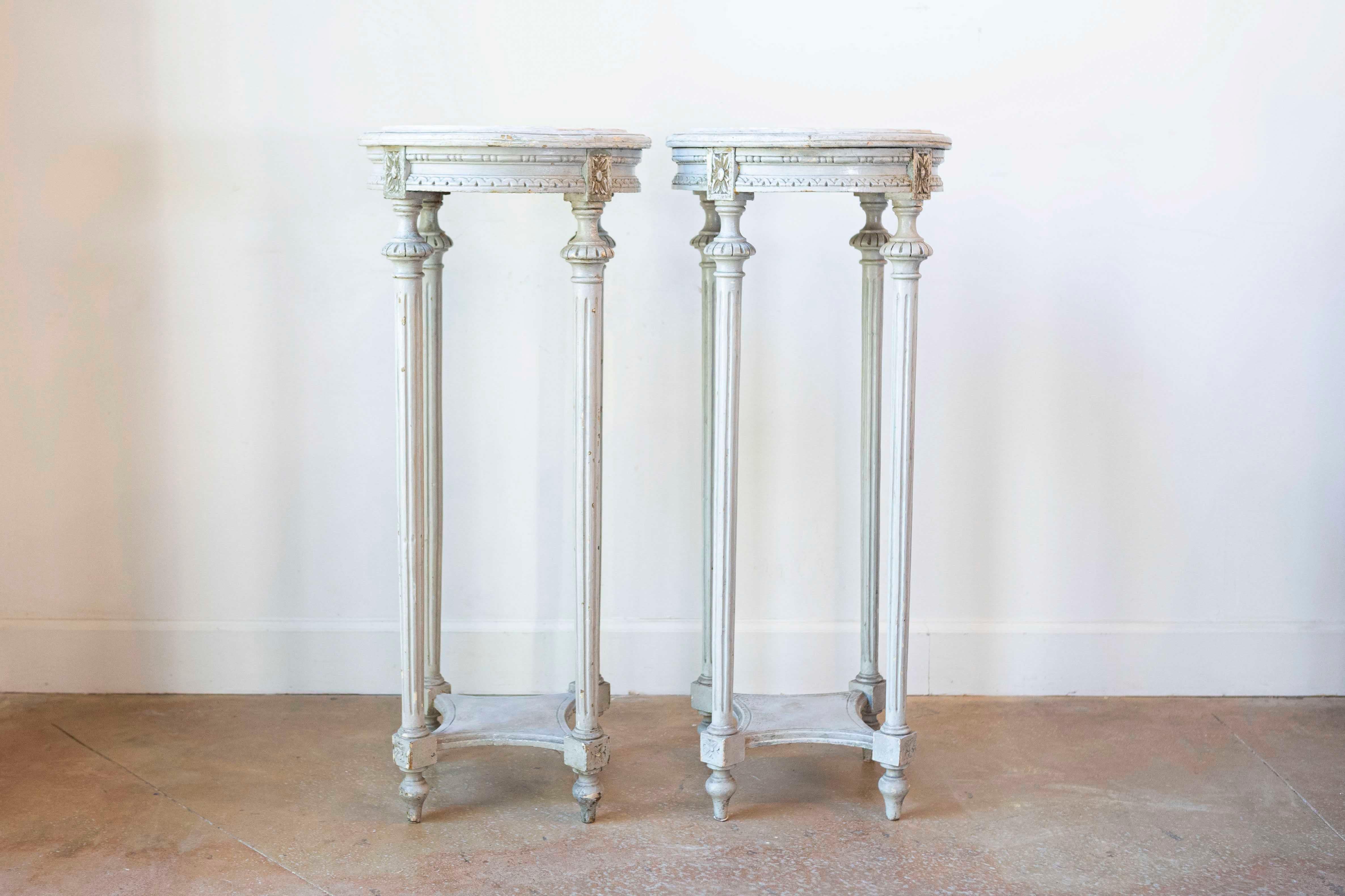 A pair of Swedish neoclassical painted wood pedestal stands from the early 19th century, with Carrara marble tops. Born in Sweden during the second quarter of the 19th century, each of this pair of neoclassical stands features a circular top made of