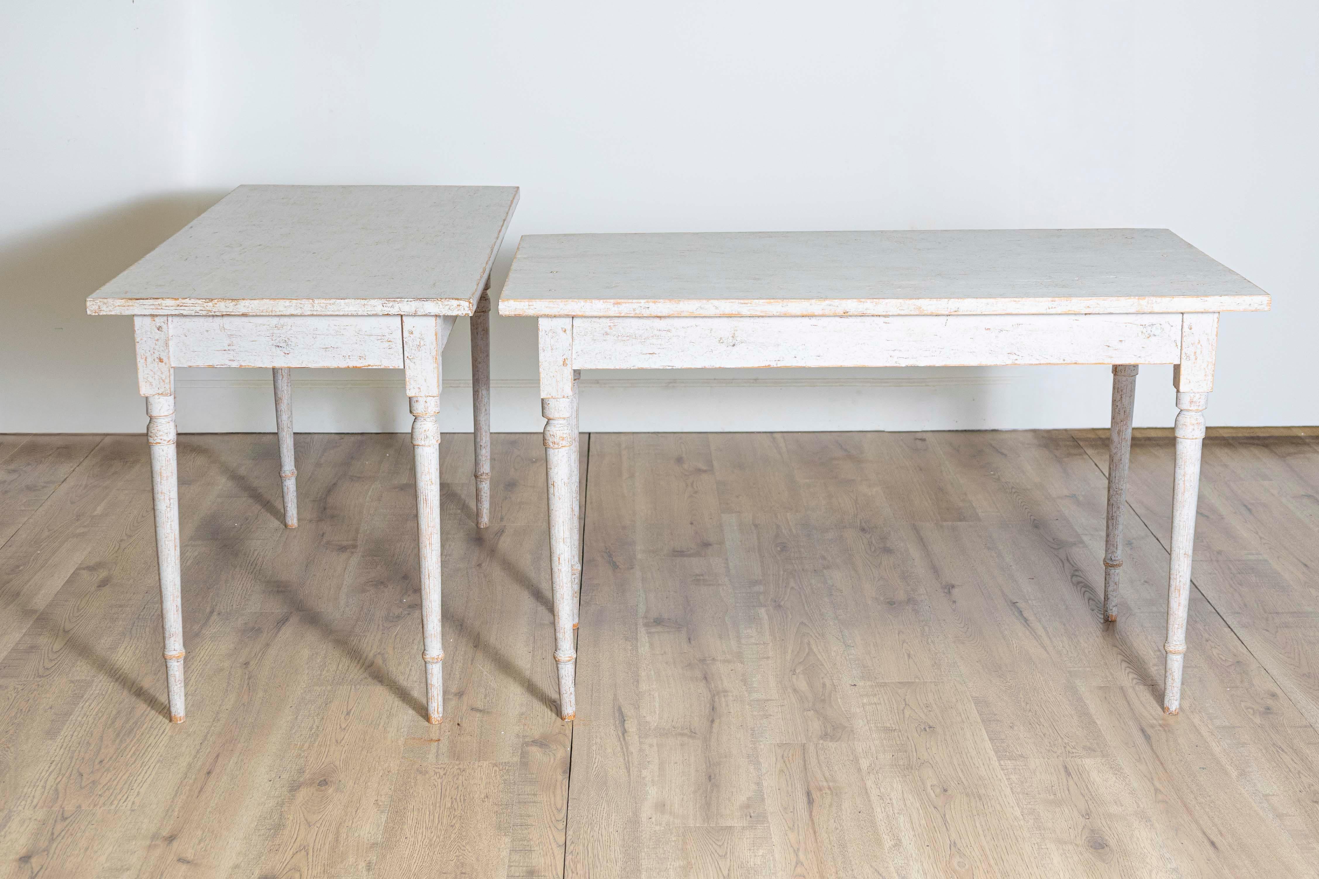 Paire de tables d'appoint suédoises en bois peint en gris clair, datant d'environ 1840, avec une finition vieillie et des pieds cylindriques et effilés. Voici une paire captivante de tables d'appoint suédoises en bois peint, vers 1840, d'une