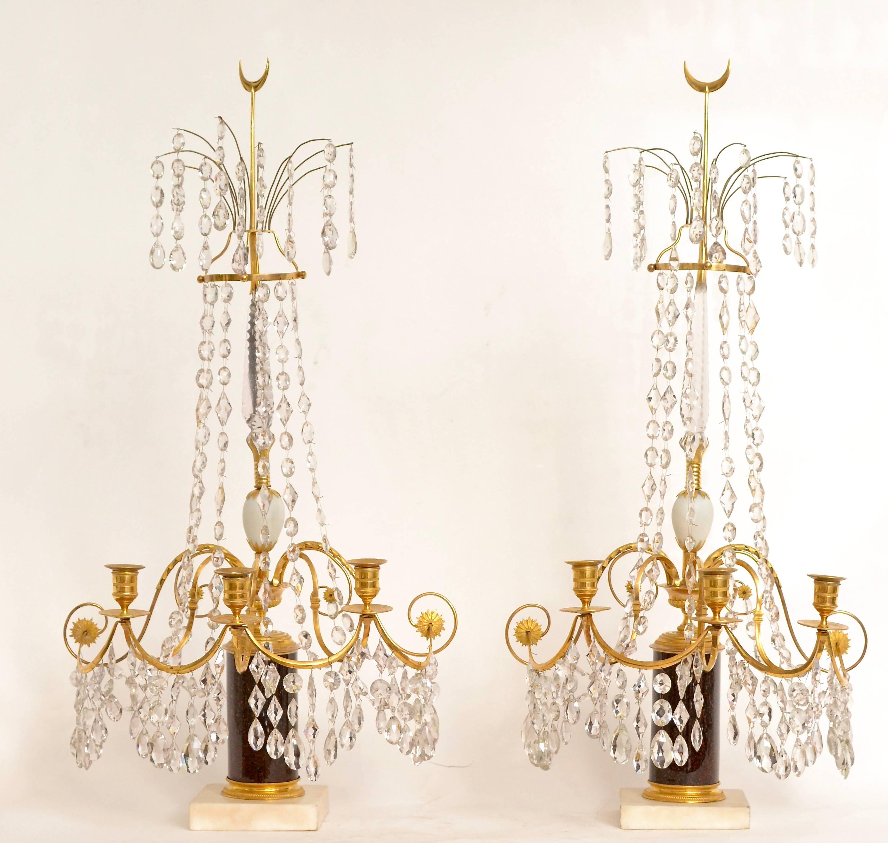 A pair of Swedish 18th century Gustavian crystal and gilt bronze candelabra with white marble and faux porphyry bases. This is a rare model.