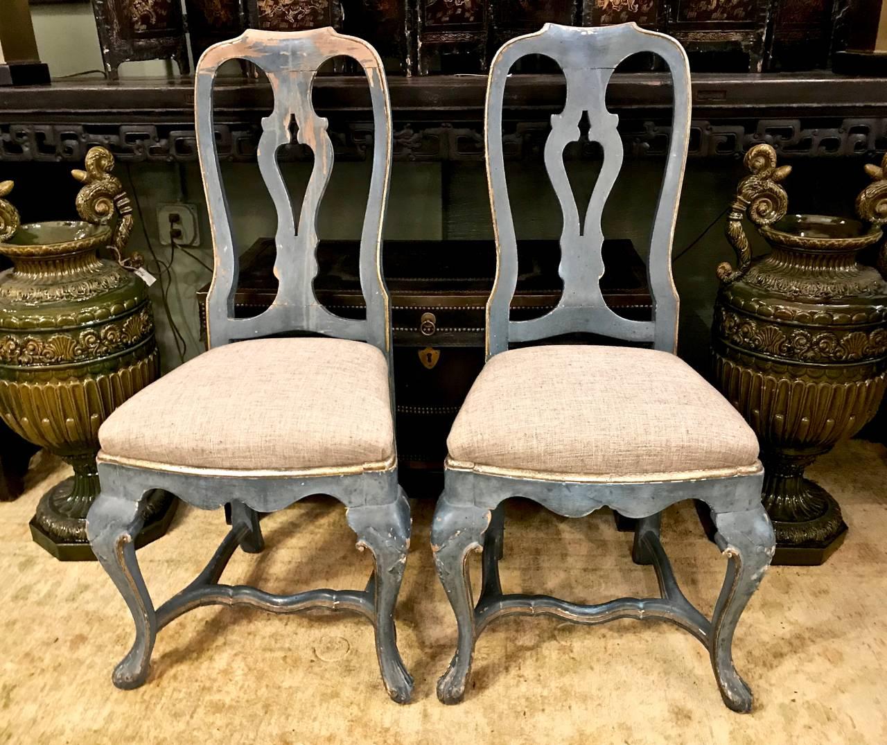 This a superb pair of circa 1760-1770 Swedish Rococo side chairs that preserve their original moody blue-gray paint. The chairs are classic and unsophisticated in form. Both chairs retain their horse hair upholstery structure and are on their way to