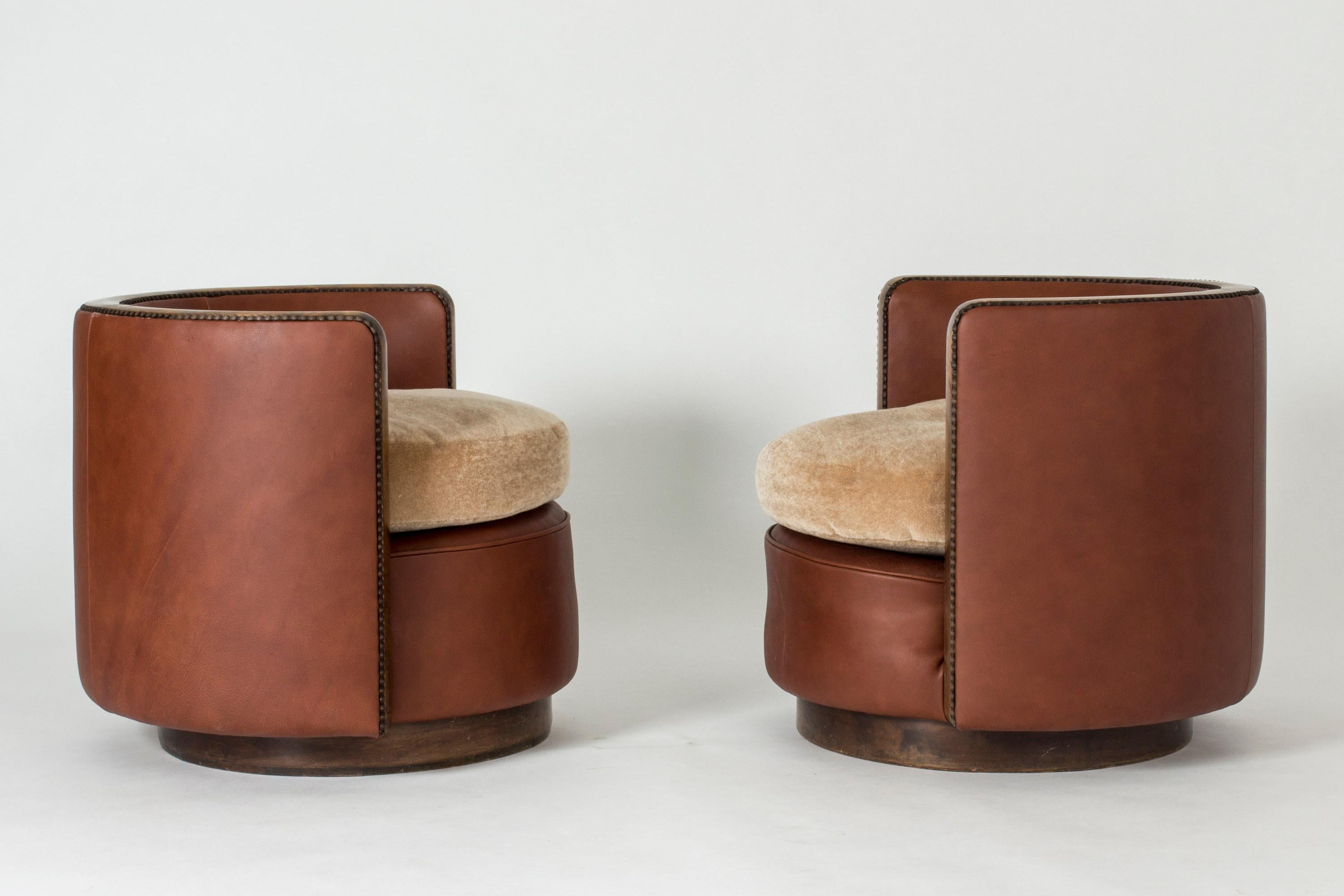 Pair of amazing Swedish 1930s lounge chairs, in a low, cylindrical design. Upholstered with leather and loose, mohair cushions. Wood details on the upper edge and front of the chairs. Restored to original condition. Price is for the pair. Seat