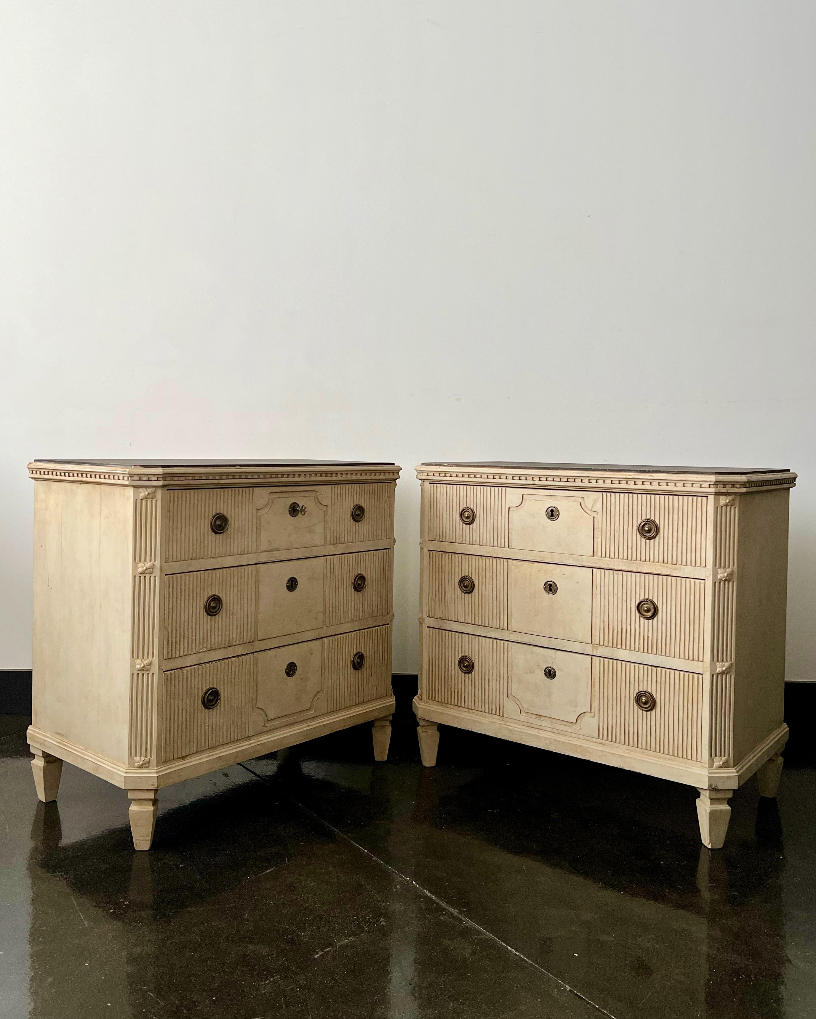 Pair of Swedish 19th century chest of drawers with three reeded drawer fronts, canted corner posts, handsome hardwares and dentil molding in cream color under the darker black/gray-shaped top,
Sweden, circa 1860.
Surprising pieces and objects,
