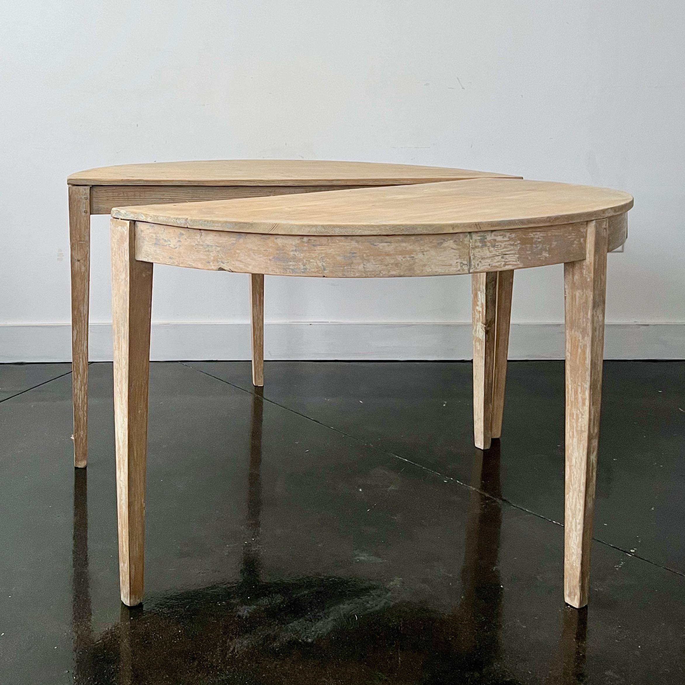 Pair of 19th century Swedish demi-lune consoles dry scraped several layers of old paint to its most original finish.
Half-moon shape top supported by long slender tapered legs.
Tables are free standing for separate use or putting them together as