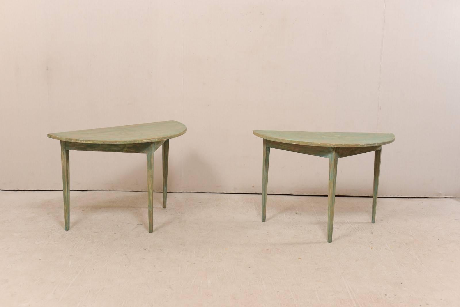 A pair of 19th century Swedish painted wood demi-lune tables. This pair of Swedish demilune tables from the 1880s features a semi-circular top over a triangular shaped apron. These demi lune tables are each raised upon three squared and gently