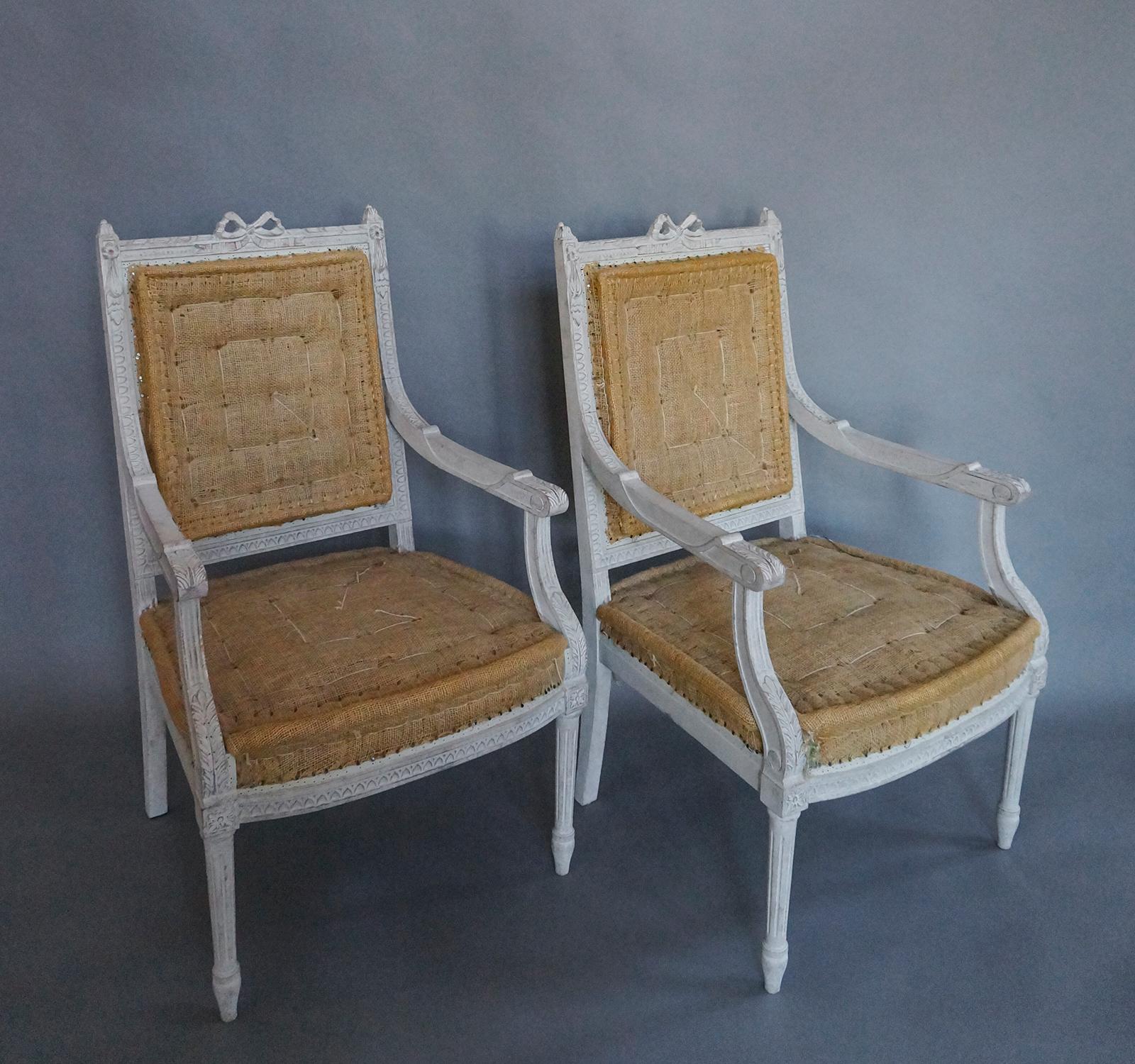 Pair of Gustavian style armchairs, Sweden, circa 1900, with nicely carved detail. Solid back with a carved bow in the center and foliate swags at the sides. The arms have space for upholstered manchettes. Lambs tongue molding covers the rounded