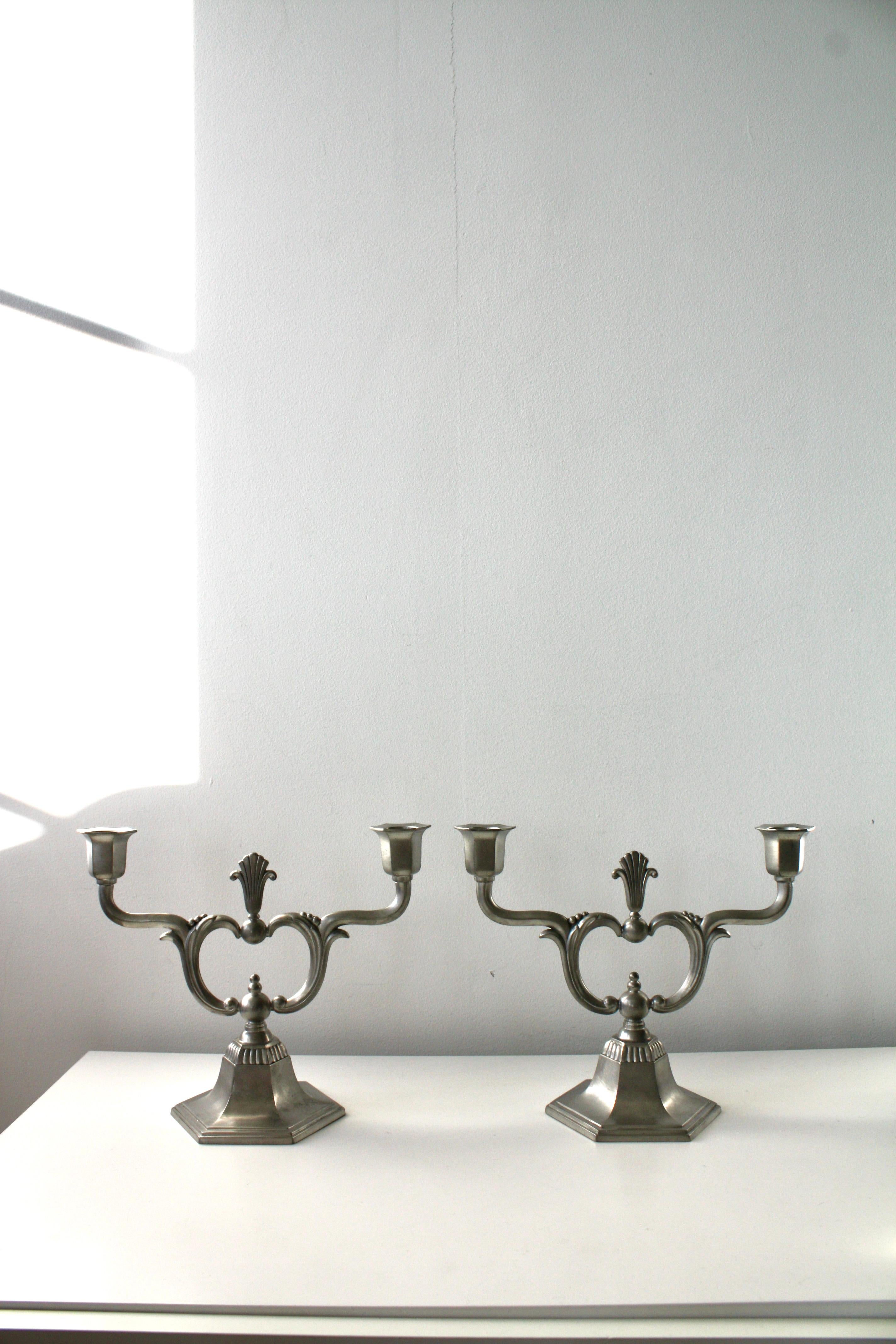 Un'elegante e raffinata coppia di candelieri svedesi in peltro Art Déco di C.C. Hallberg, Svezia, risalente al 1930 circa. 

Questi candelieri sono tipici del design e della qualità scandinava e presentano le classiche caratteristiche dell'Art Déco: