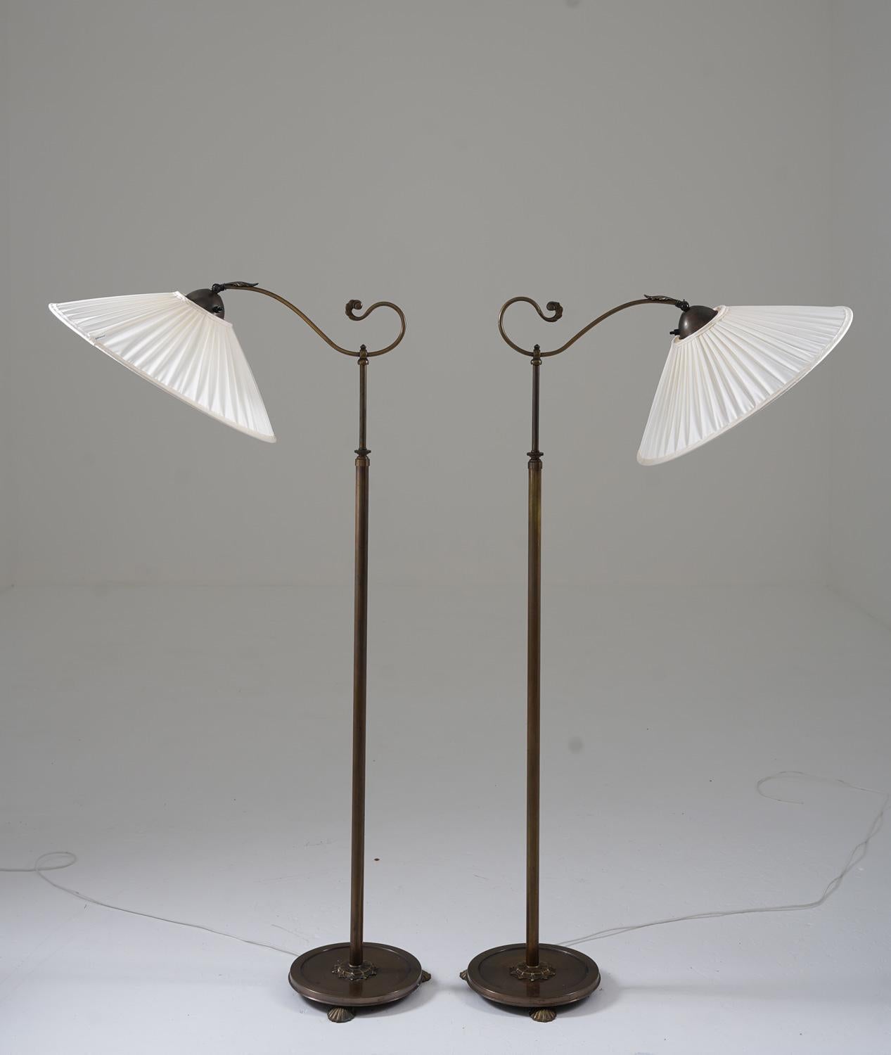 Lovely art deco or Jugend floor lamps manufactured in the 1930s. 
These lamps are made of bronze-plated brass and are constructed with impressive quality. 
The height is adjustable between 135-165cm (53-65