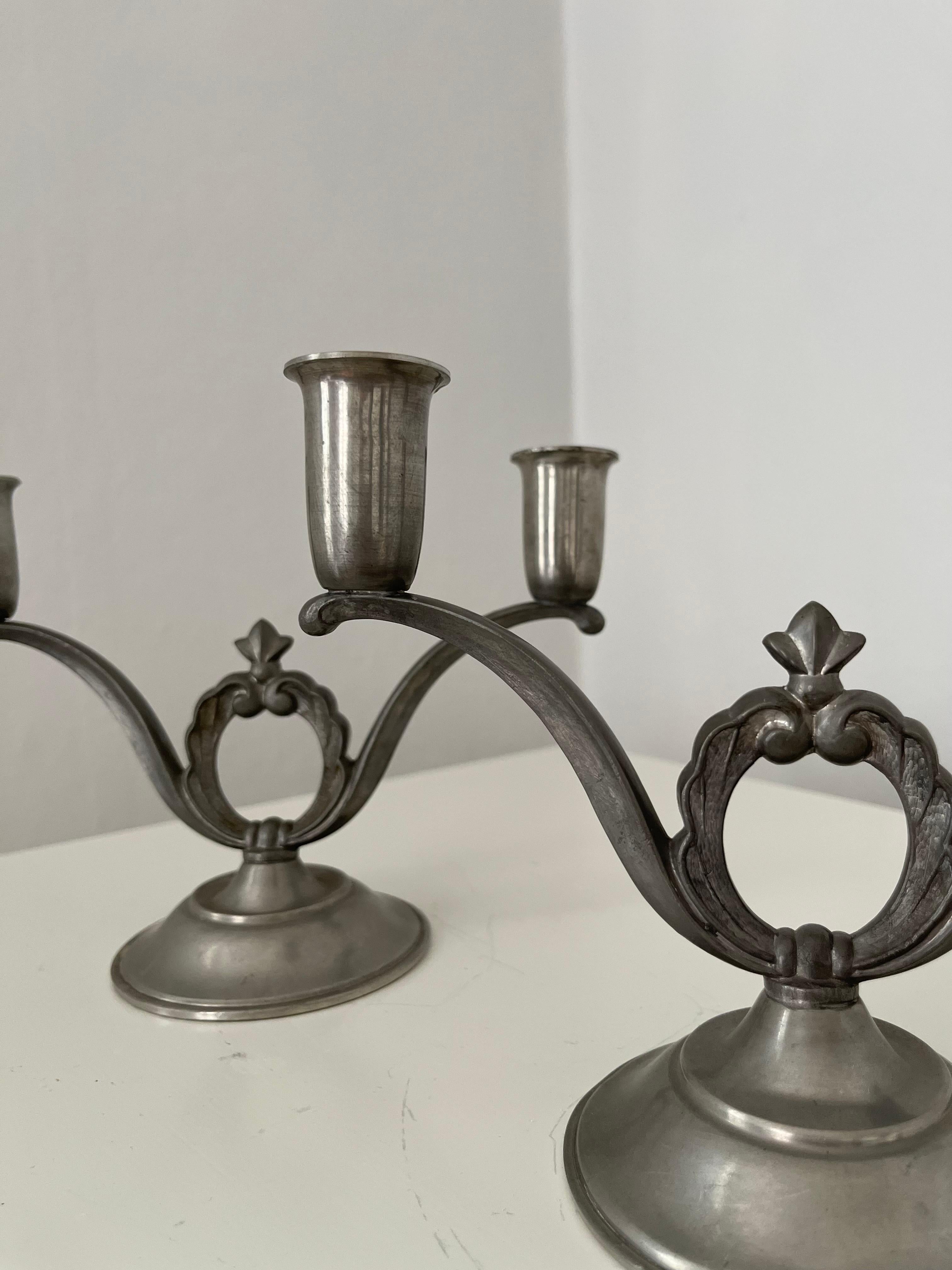 Coppia di candelieri svedesi in peltro Art Déco, con timbro 'Svenskt Tenn Handarbete I8', anni '30

Coppia decorativa di candelieri svedesi in peltro Art Deco degli anni '30, ciascuno con due portacandele progettati per candele standard. Sul fondo