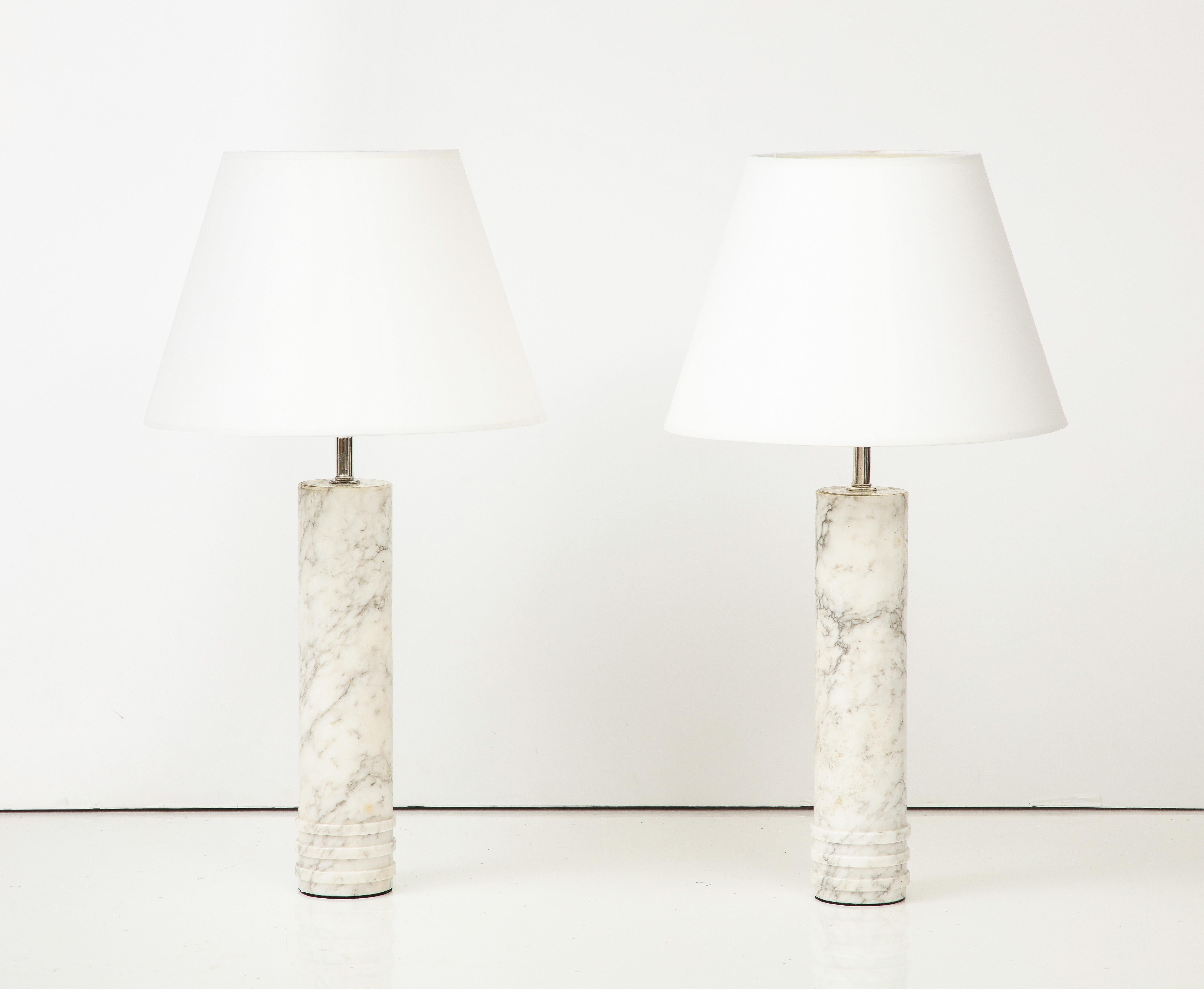 A pair of Swedish table lamps in white carrara marble produced by Bergboms, Sweden, Model B-10, circa 1960s. Solid turned marble with three lower bands, re wired for the US. New shades. Makers label on base. (under protective felt).