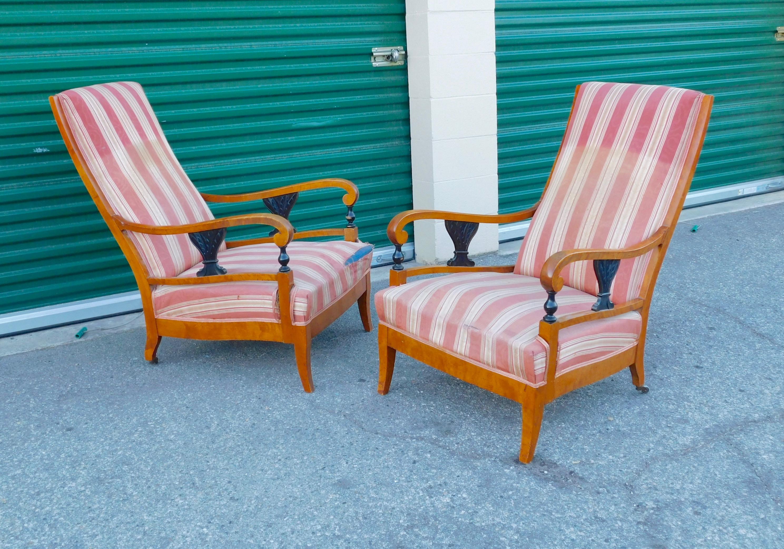 Pair of original Swedish Biedermeier revival armchairs in golden flame birch wood with ebonized acanthus leaves and details. Age appropriate patina is apparent on the wood. Please see photos With original castors on back legs. Crafted in Sweden in