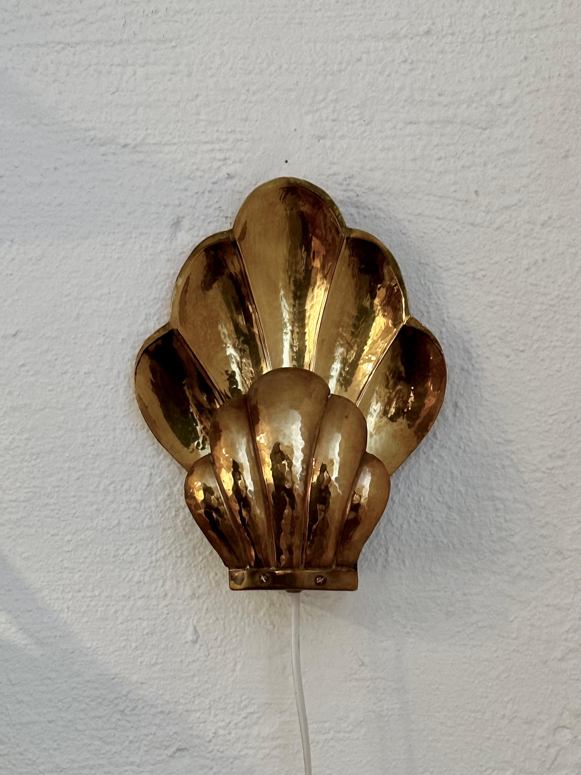 Pair of clam shaped hammered brass wall sconces, in the manner of Lars Holmström, by Nils Andersson, Arvika Konstsmide, in the second half of the 20th century. Simple, elegant design which reflects the light beautifully. Arvika Konsthantverk was