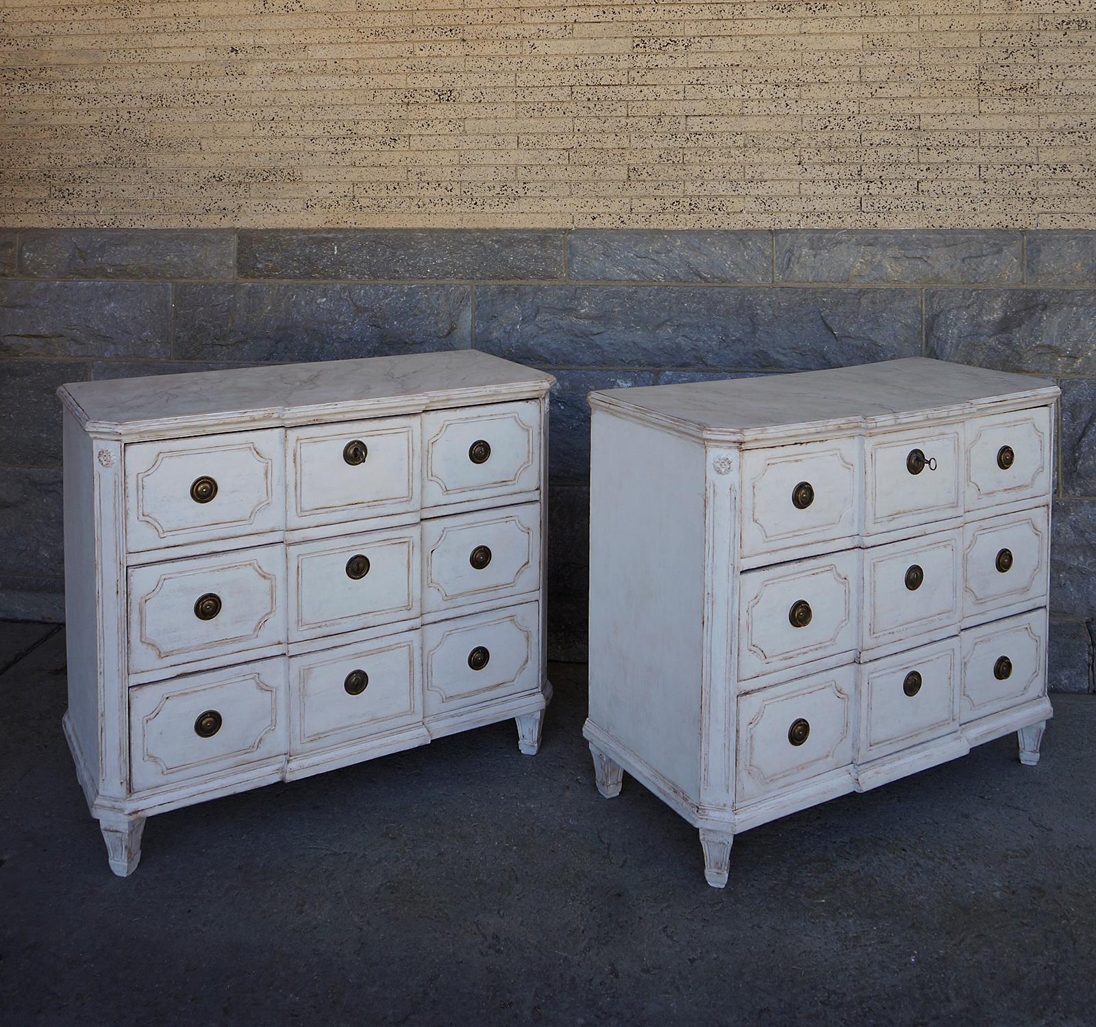 Pair of three drawer chests, Sweden, circa 1860, with shaped tops, and drawers with incised detail. The canted corners have applied rosettes and vertical fluting. Original brass hardware. The feet have been replaced.