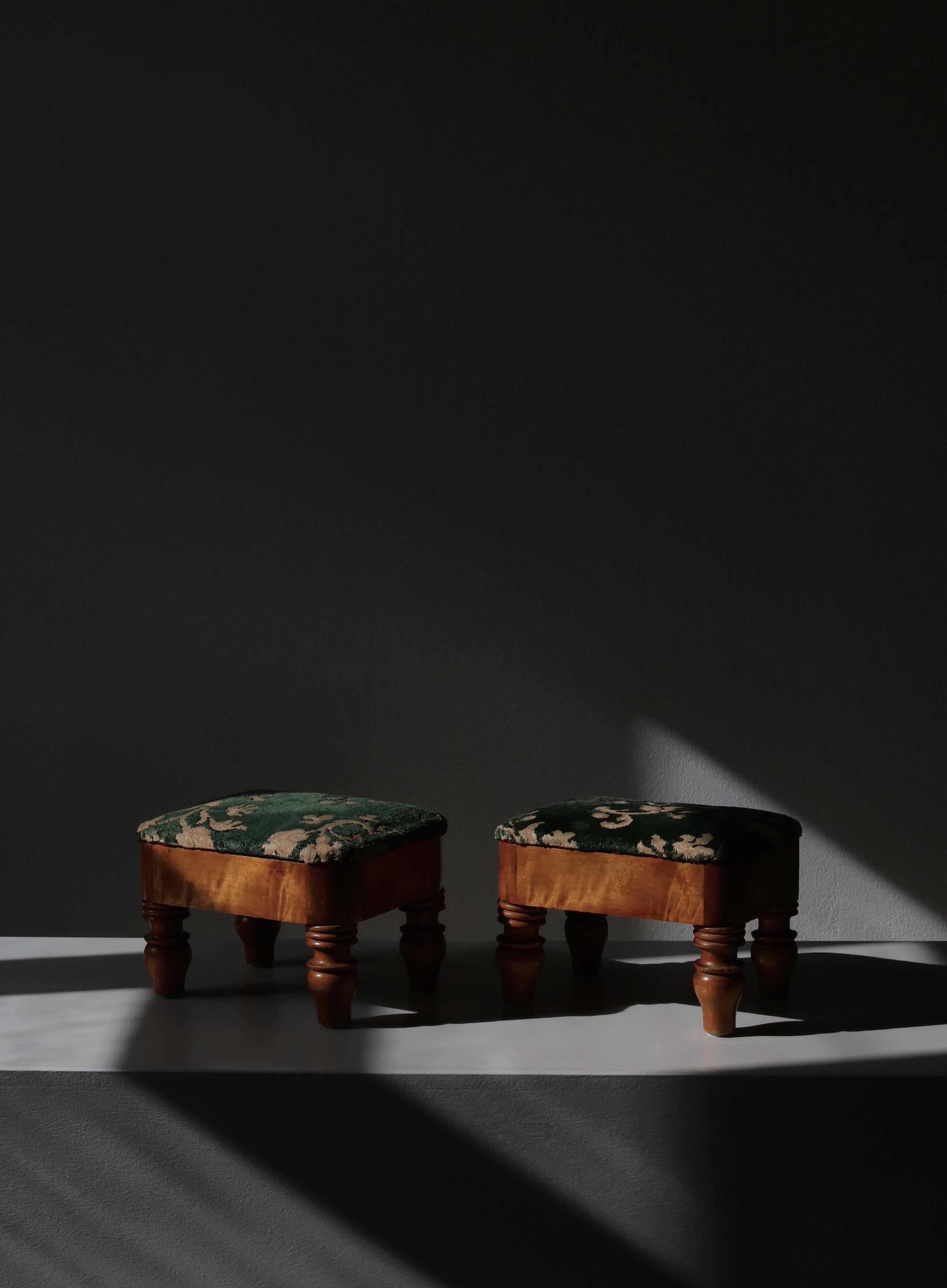 A pair of small charming footstools made by a Swedish cabinetmaker in the early 20th century. The stools are made from Scandinavian birch tree with a beautiful patina. Upholstered in green and white velvet.