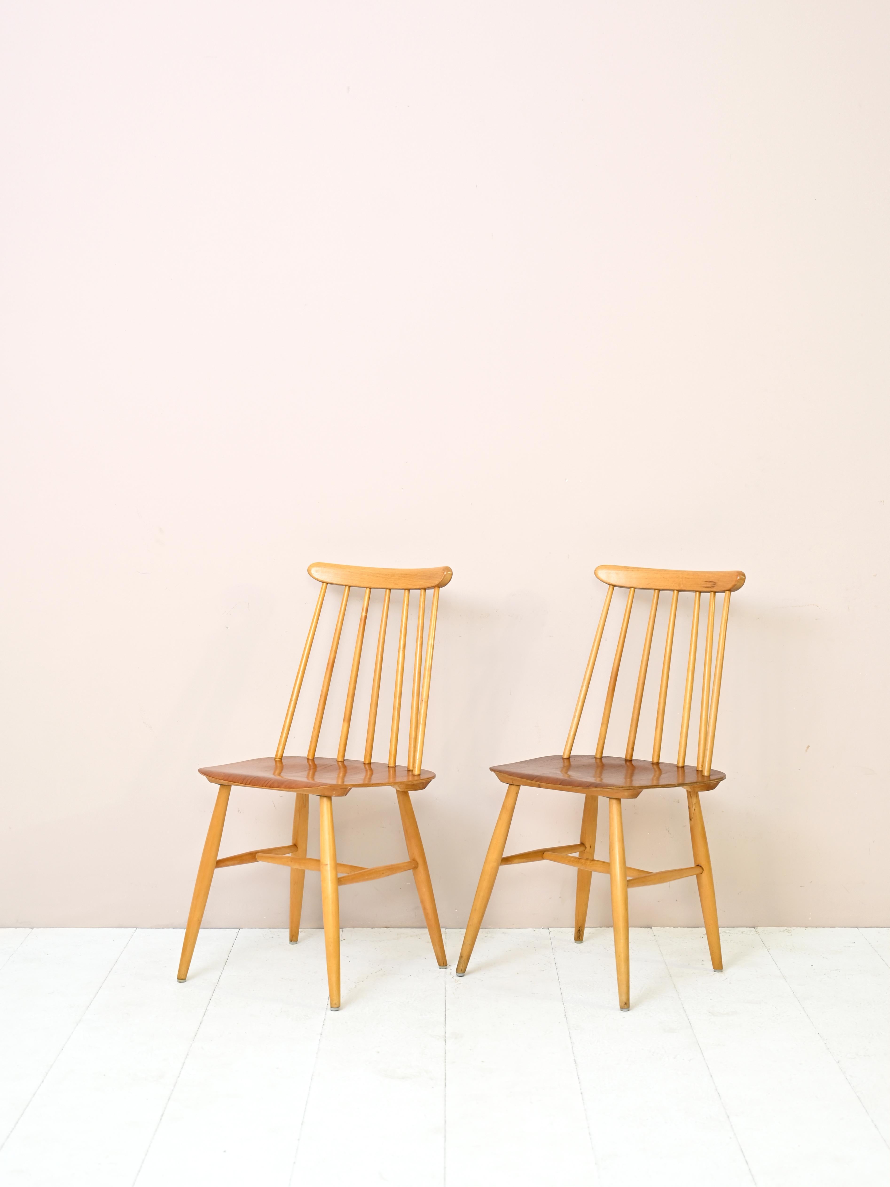Scandinavian chairs with authenticity of originality
Pair of birch and teak chairs produced by Edsby Verken.

The birch wood frame consists of a wide seat and a backrest formed by seven
vertical spindles. The seat is made of teak.
The tapered,