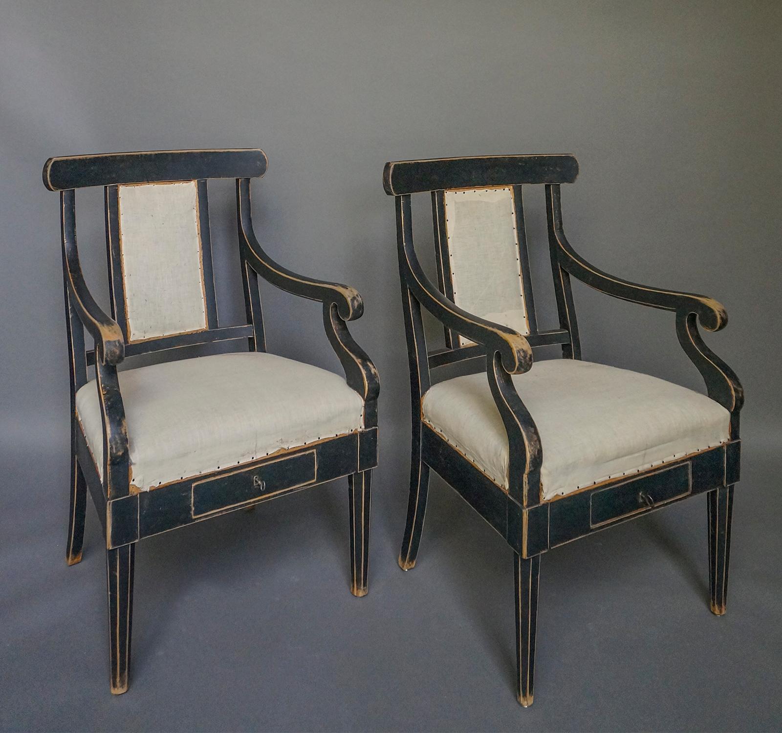 Pair of rare Swedish armchairs, circa 1840, with a locking drawer in the front apron. Upholstered seat and back, curving armrests and hexagonal front legs. Found in a courtroom.