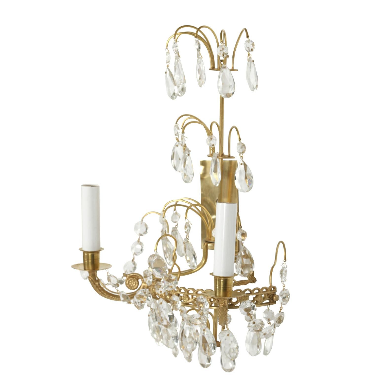 A pair of Swedish crystal and brass two-arm sconces with three tiers of crystal prisms.