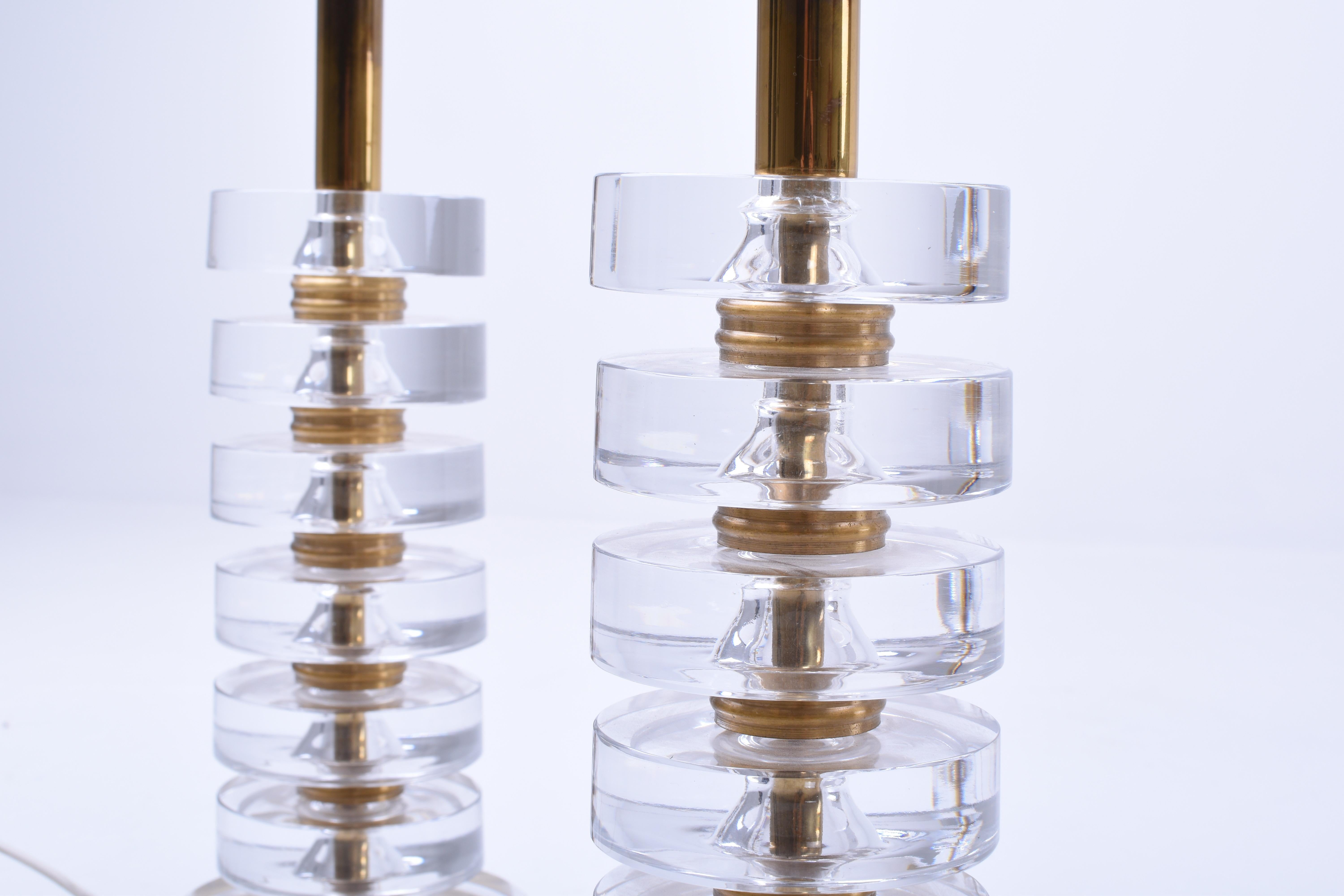 Ein Paar elegante Tischlampen von Carl Fagerlund für Orrefors. Das schöne Design der Lampen macht sie für alle Einrichtungsstile geeignet.
Die Lampen bestehen aus sechs Scheiben aus klarem Kristallglas, die durch massive Messingscheiben getrennt