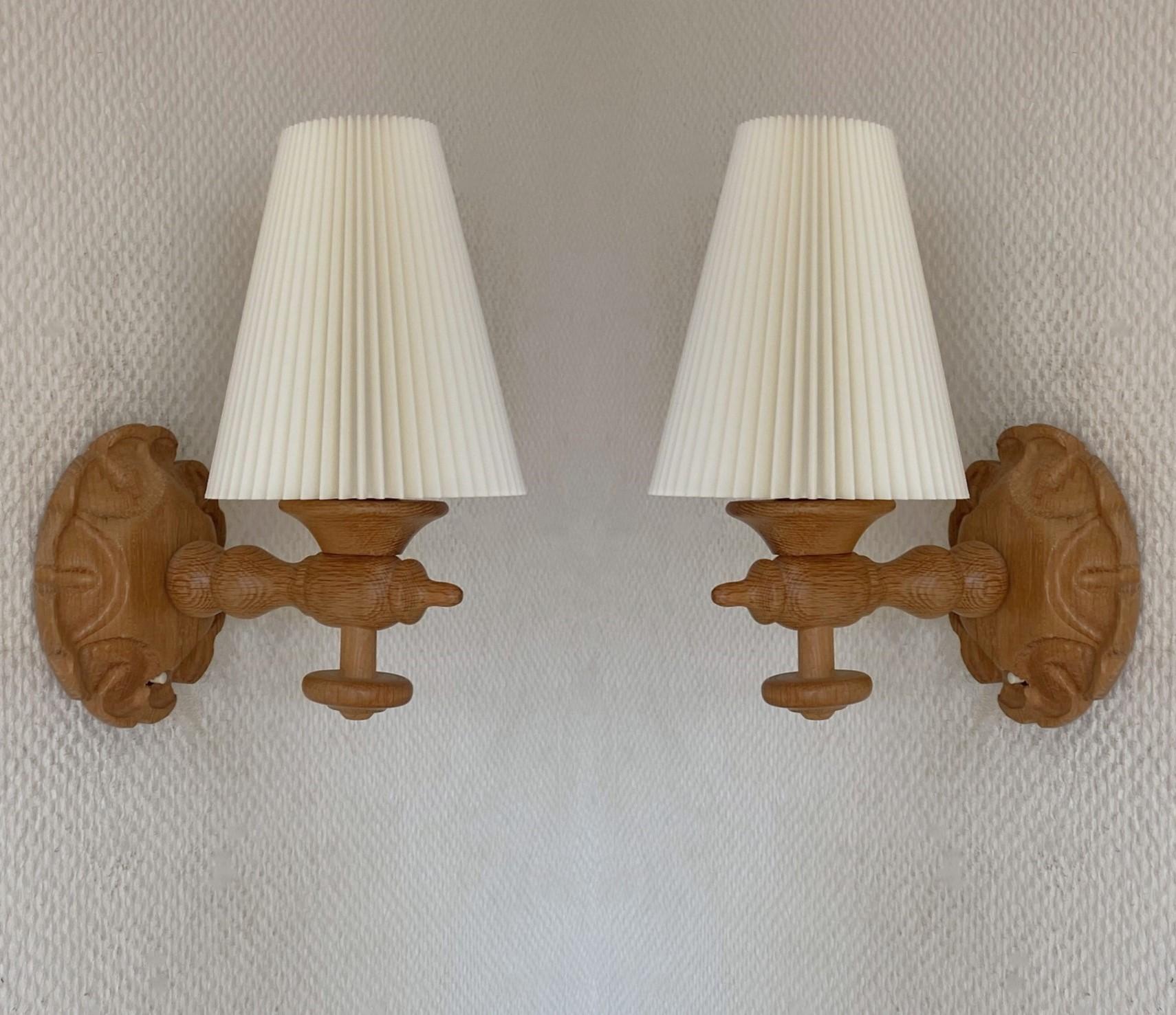 A lovely pair of solid hand-carved pine wood wall sconces designed and produced in Sweden in the 1950s. Clean lines and organic design from the Scandinavian Modern period, carved backplate in flower shape with switch to turn on and off, beautiful