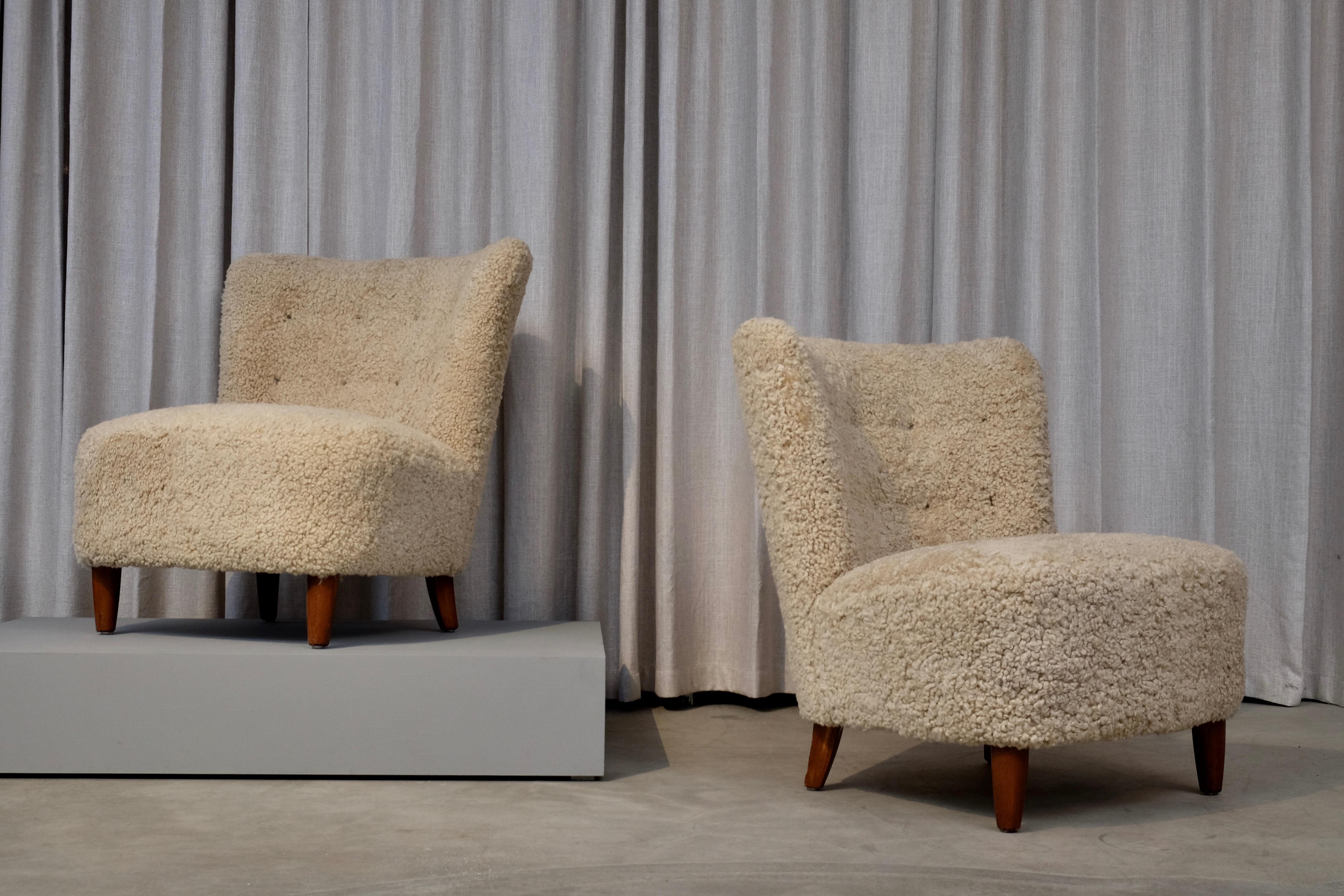 A great pair of Swedish easy chairs, early 1950s. Newly reupholstered in honey colored sheepskin. Excellent condition.